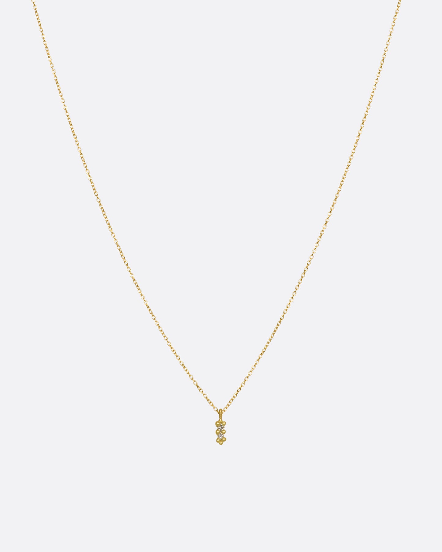 A yellow gold necklace with a double white diamond pendant. Shown from the front.