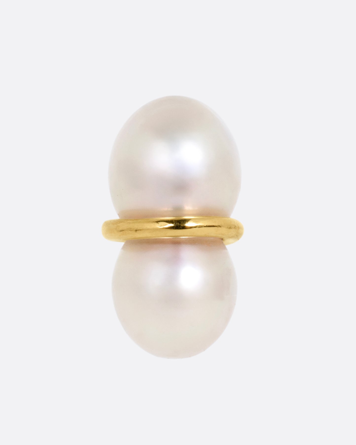 A pearl earring with a gold loop around the middle, shown from the front.