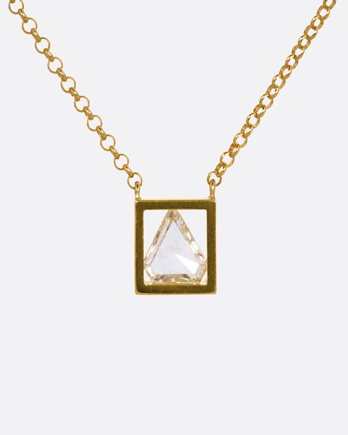 A yellow gold cable chain necklace with a triangular diamond in an open setting, shown from the front.