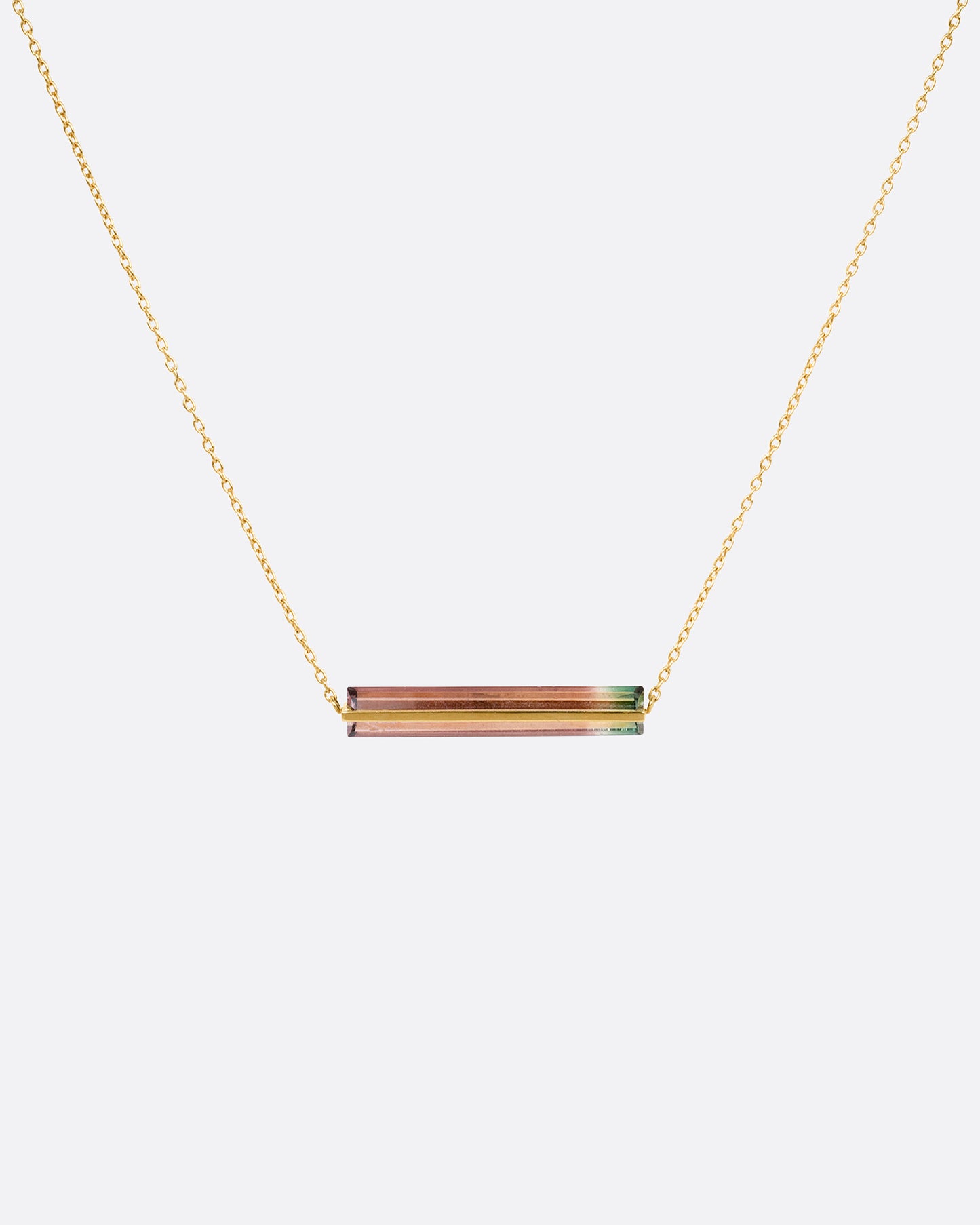 A yellow gold cable chain necklace with a watermelon tourmaline and gold bar, shown from the front.