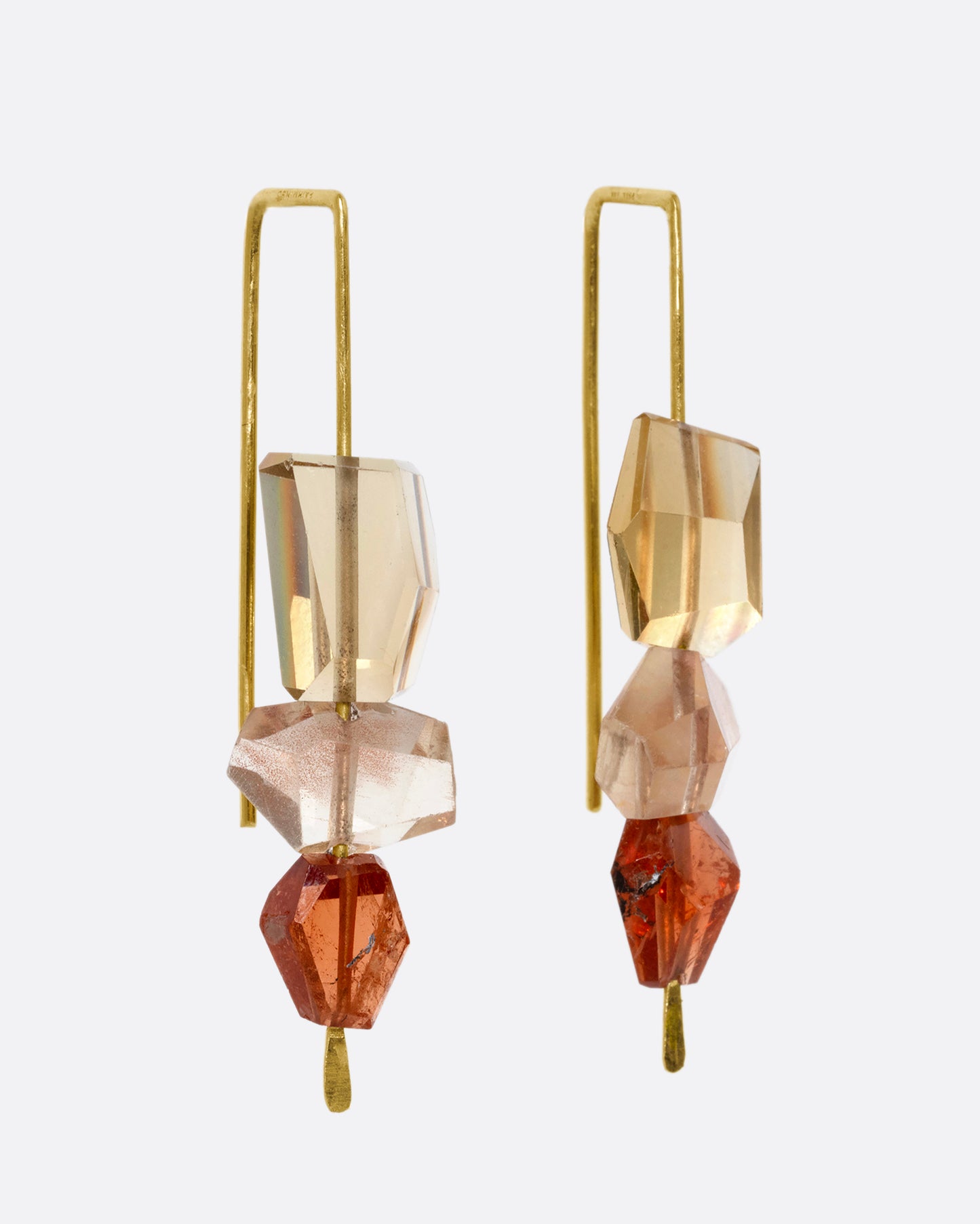 A pair of yellow gold hook earrings with a stack of three sunstones and hessonite garnets. Shown from the side.