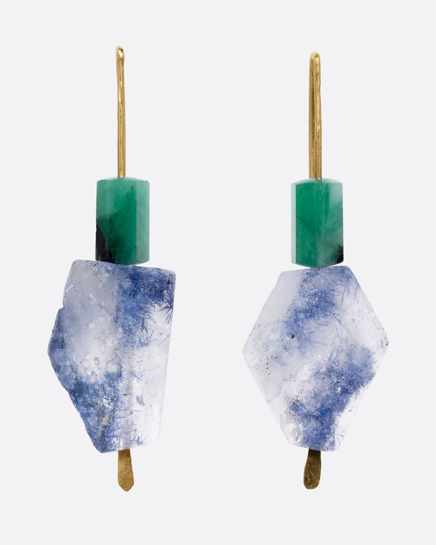 A pair of yellow gold hook earrings with a freeform dumortierite and emerald on each. Shown from the front.