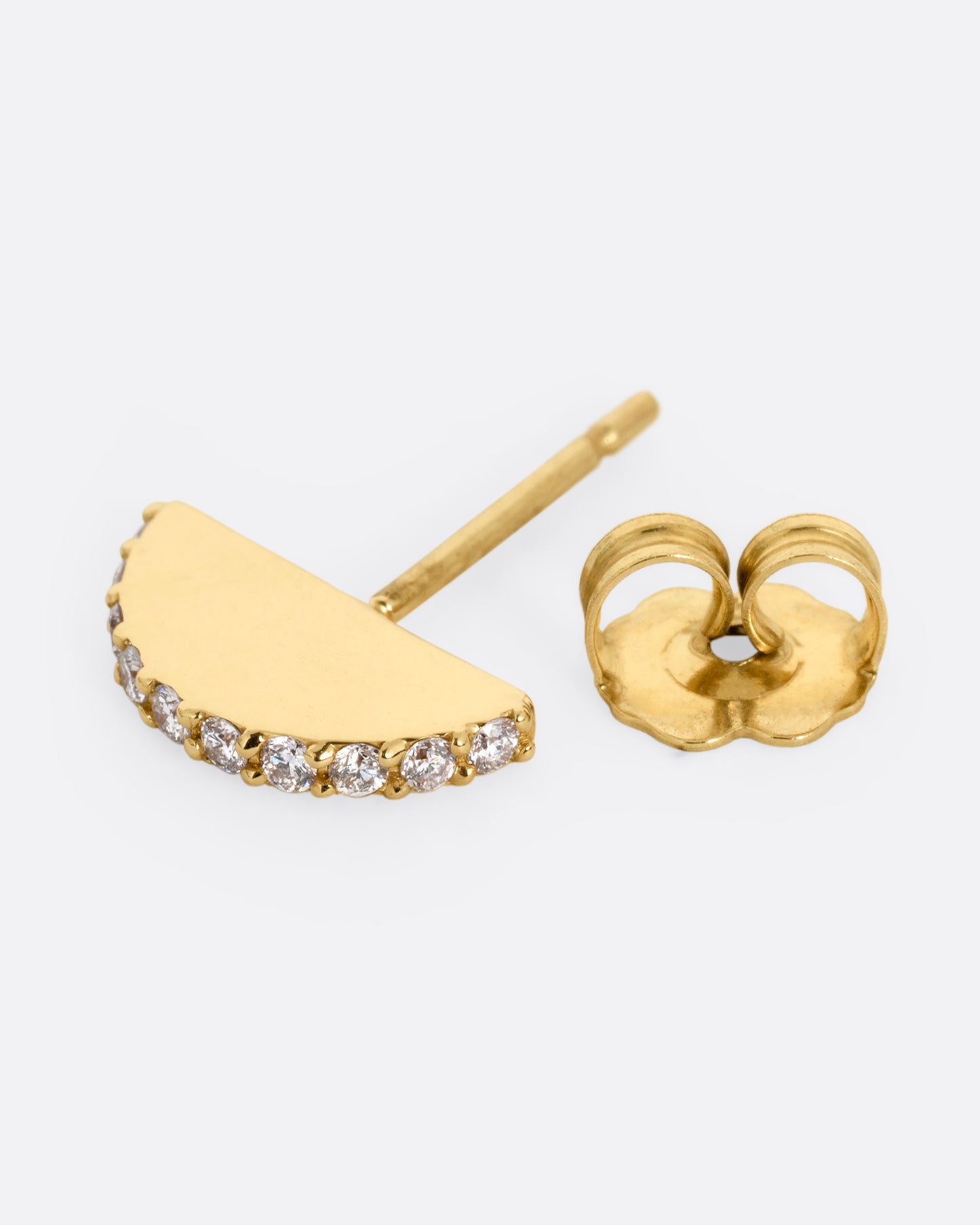 A half moon yellow gold stud with a diamond studded edge, shown on its side open.