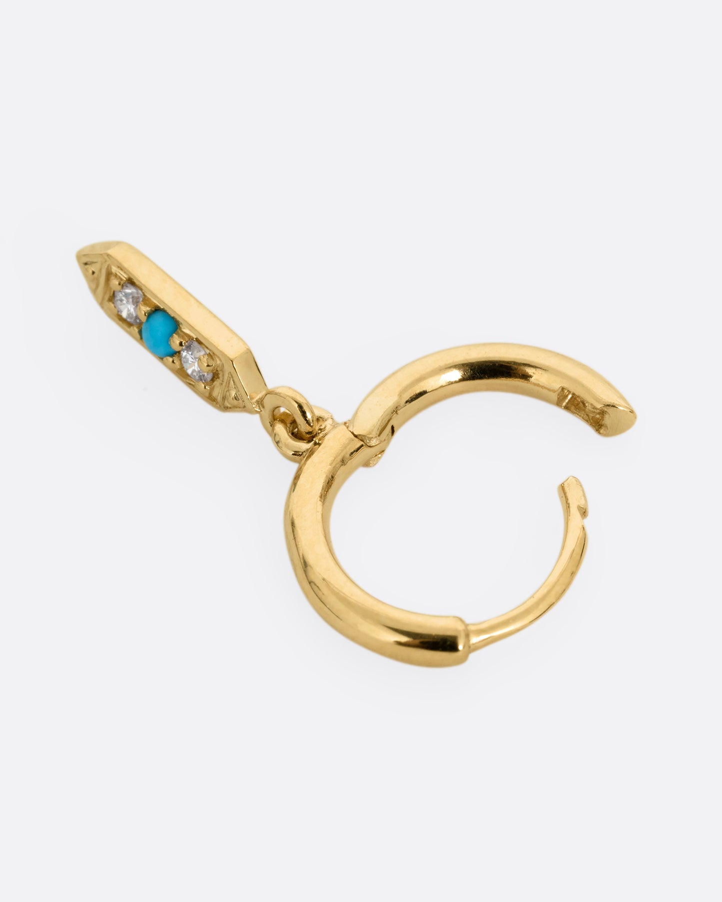 A yellow gold hoop earring with a diamond and turquoise dangle, shown open on its side.