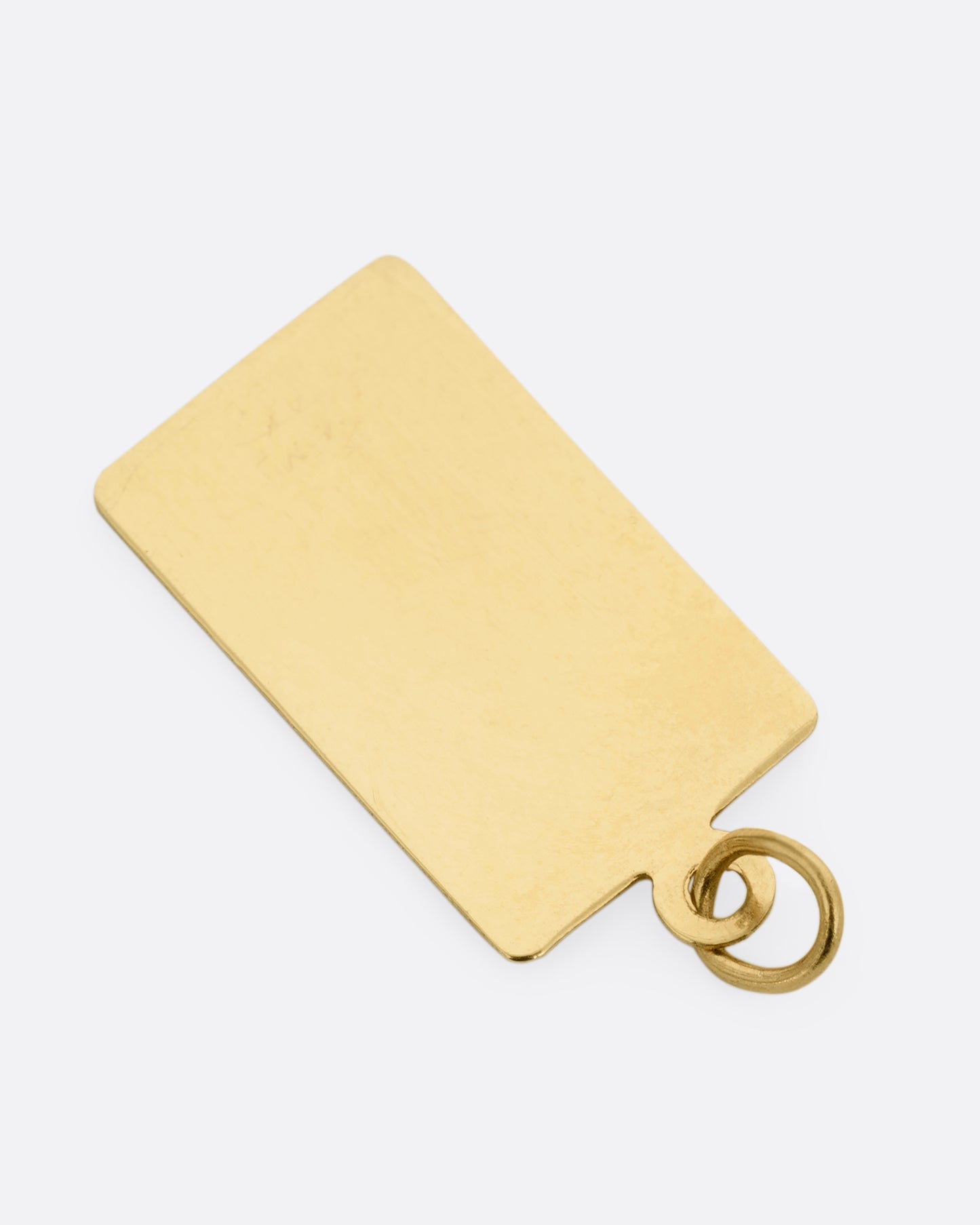 A yellow gold rectangular #1 vintage charm. Shown from the back.