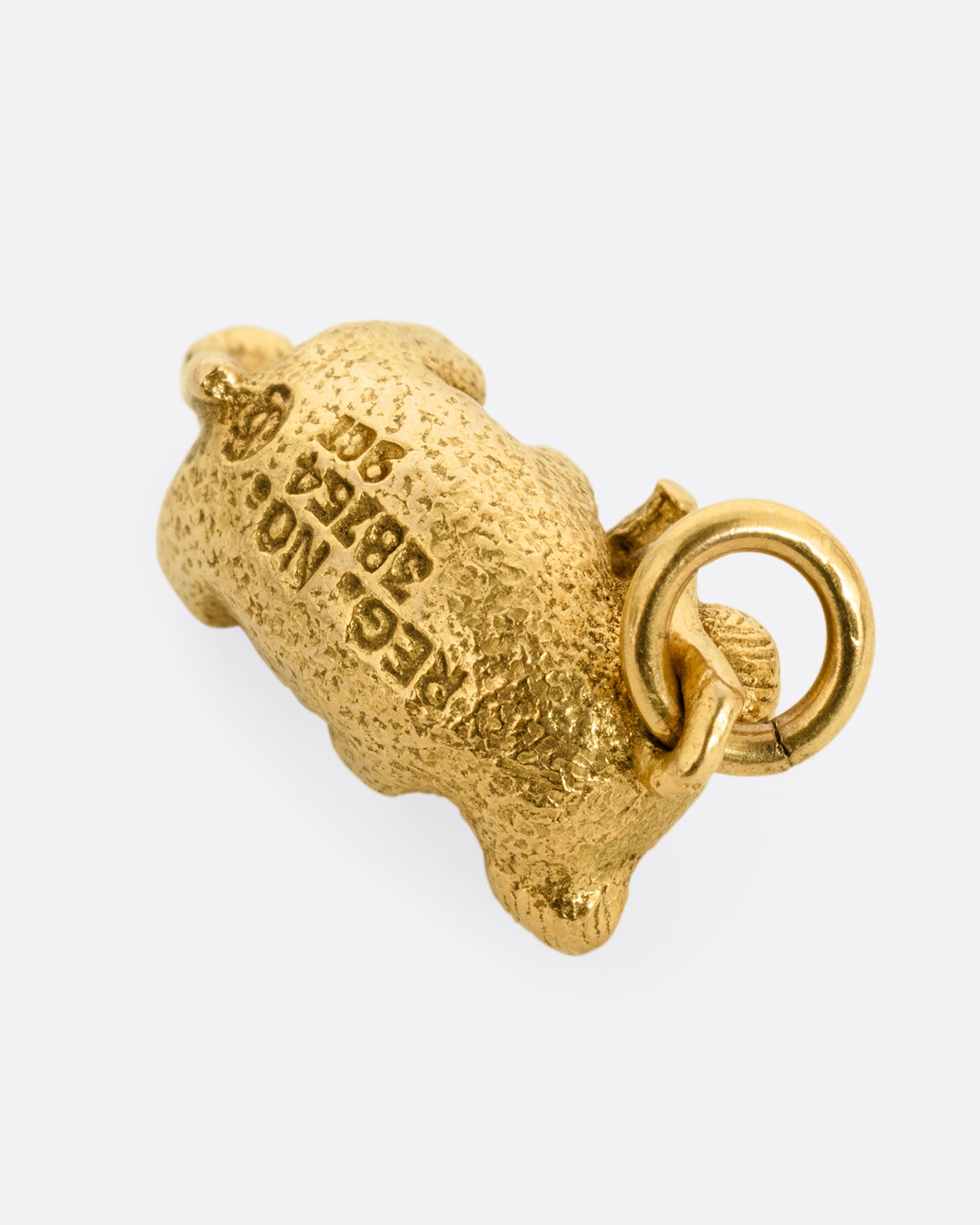 A yellow gold koala pendant shown from the back.