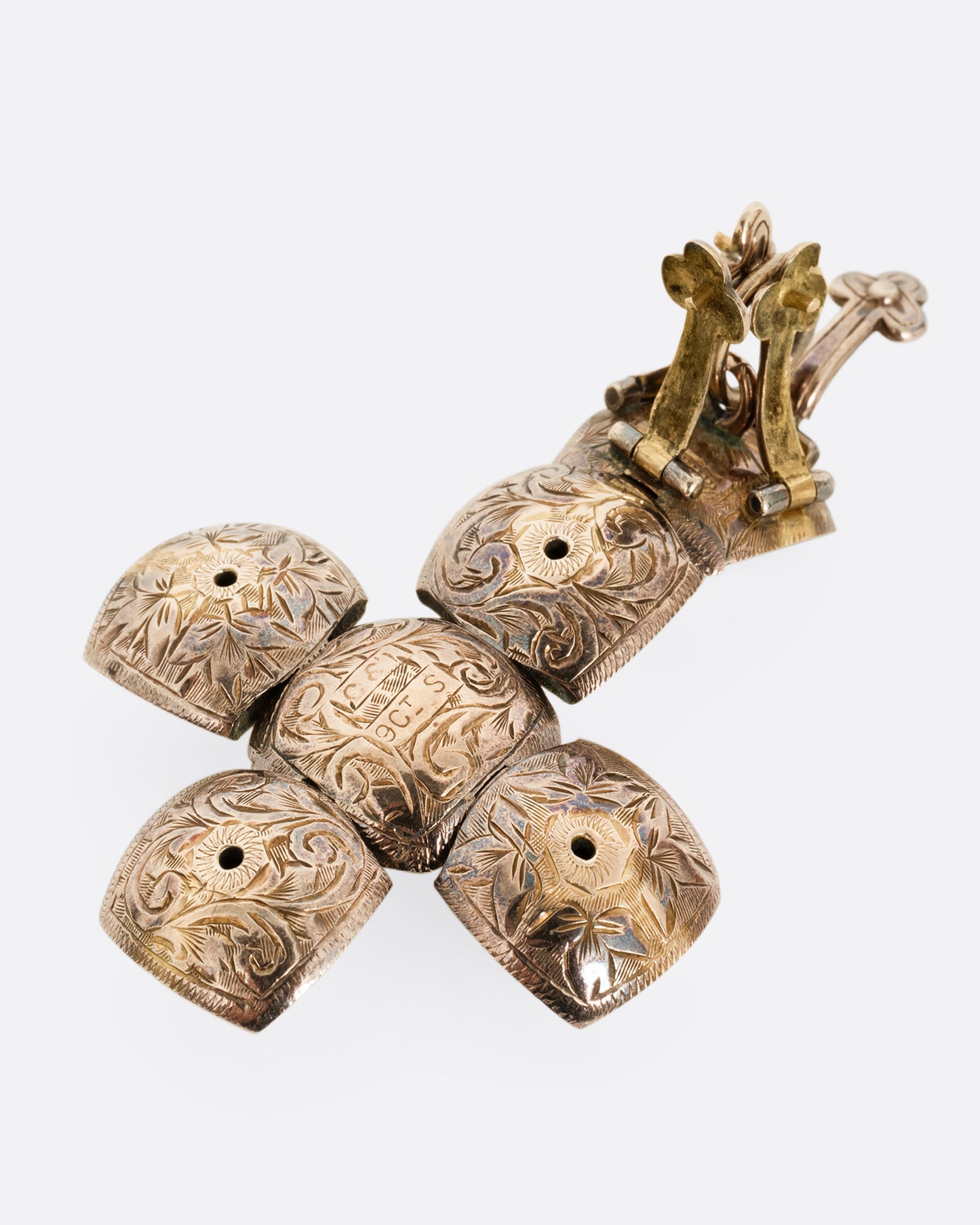 A yellow gold engraved Masonic Orb pendant shown open from the back in a dimensional cross shape.