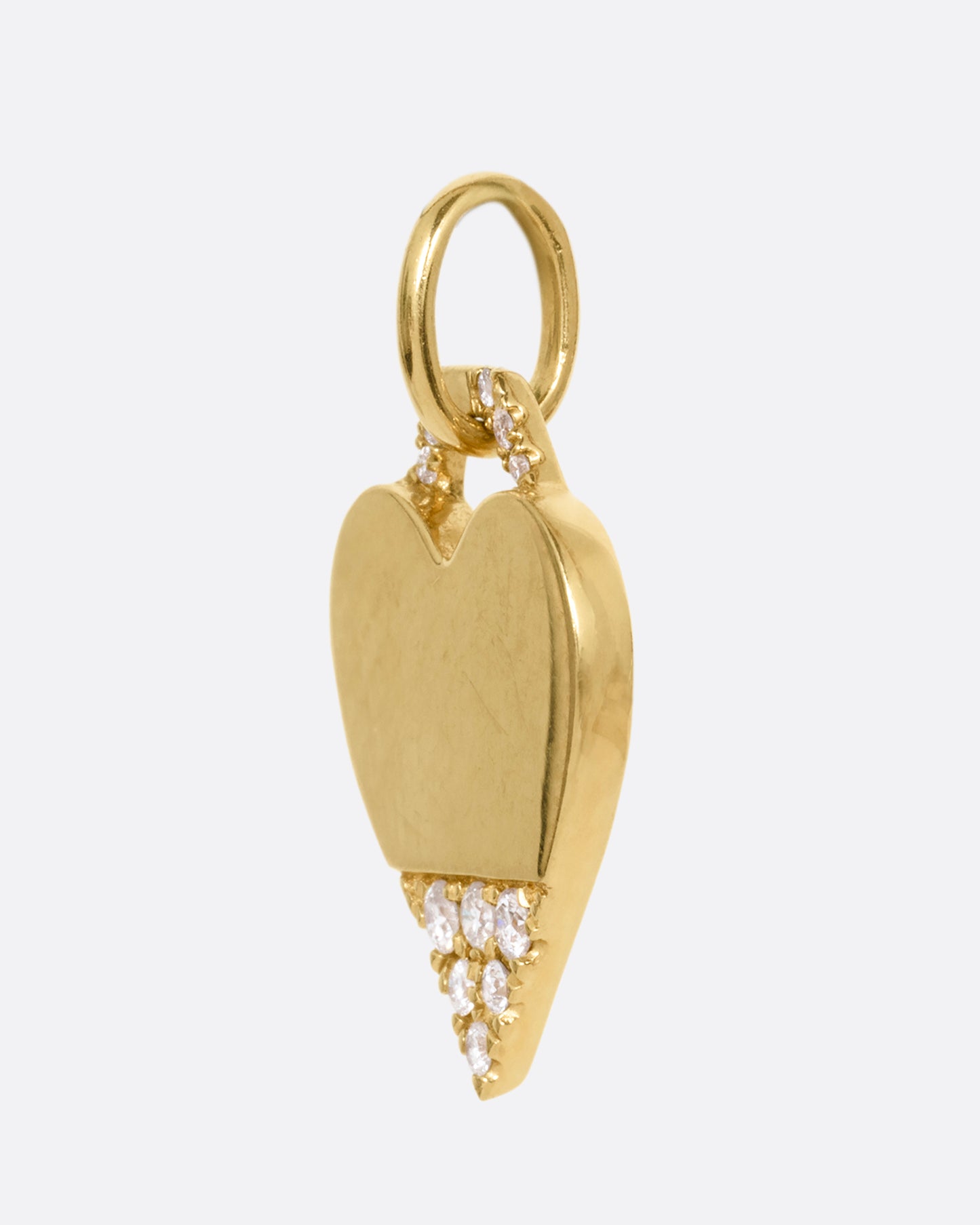 A yellow gold heart pendant with a diamond studded bail and tip, shown from the side.