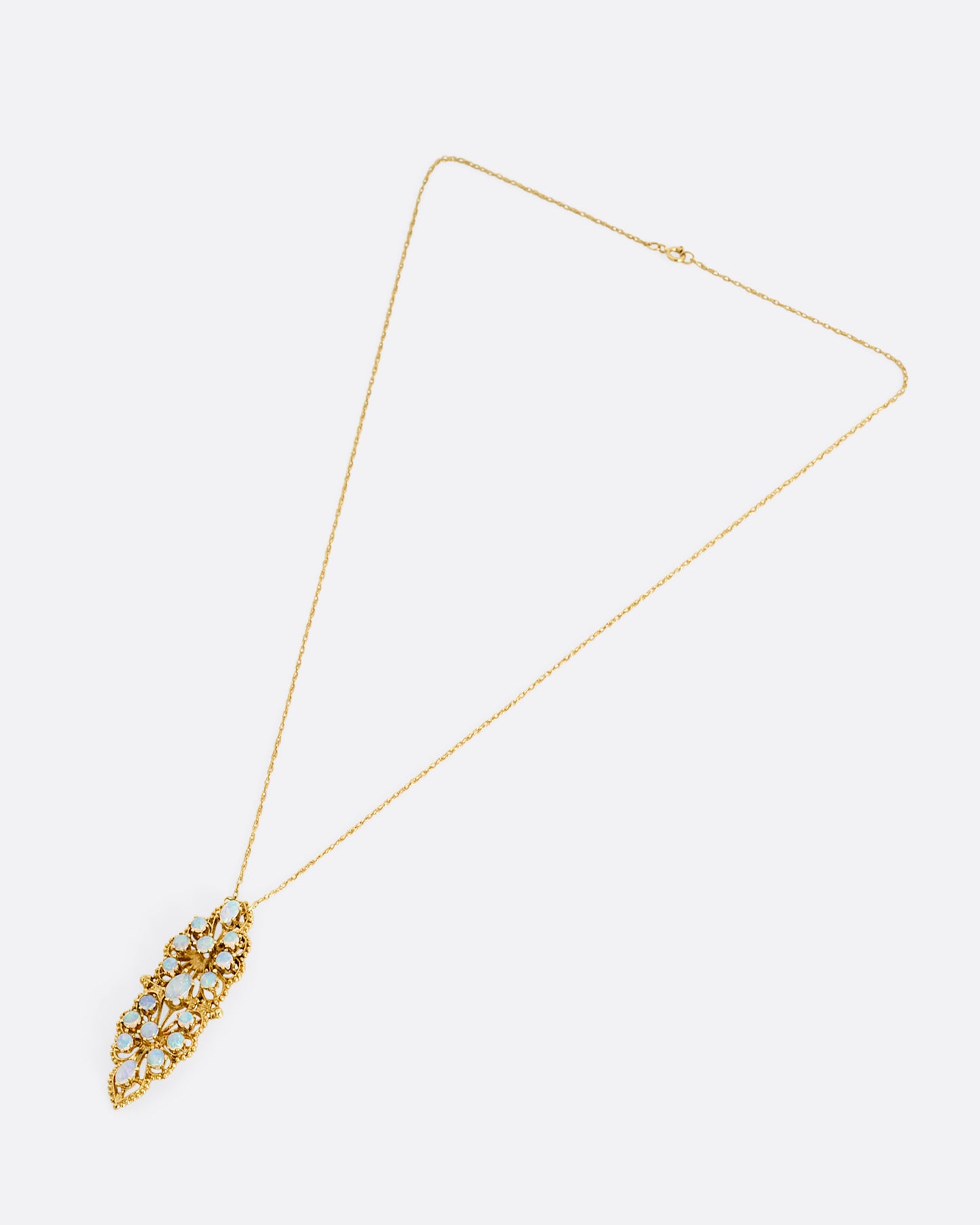 A yellow gold opal studded floral pendant, shown from the front on a cable chain.