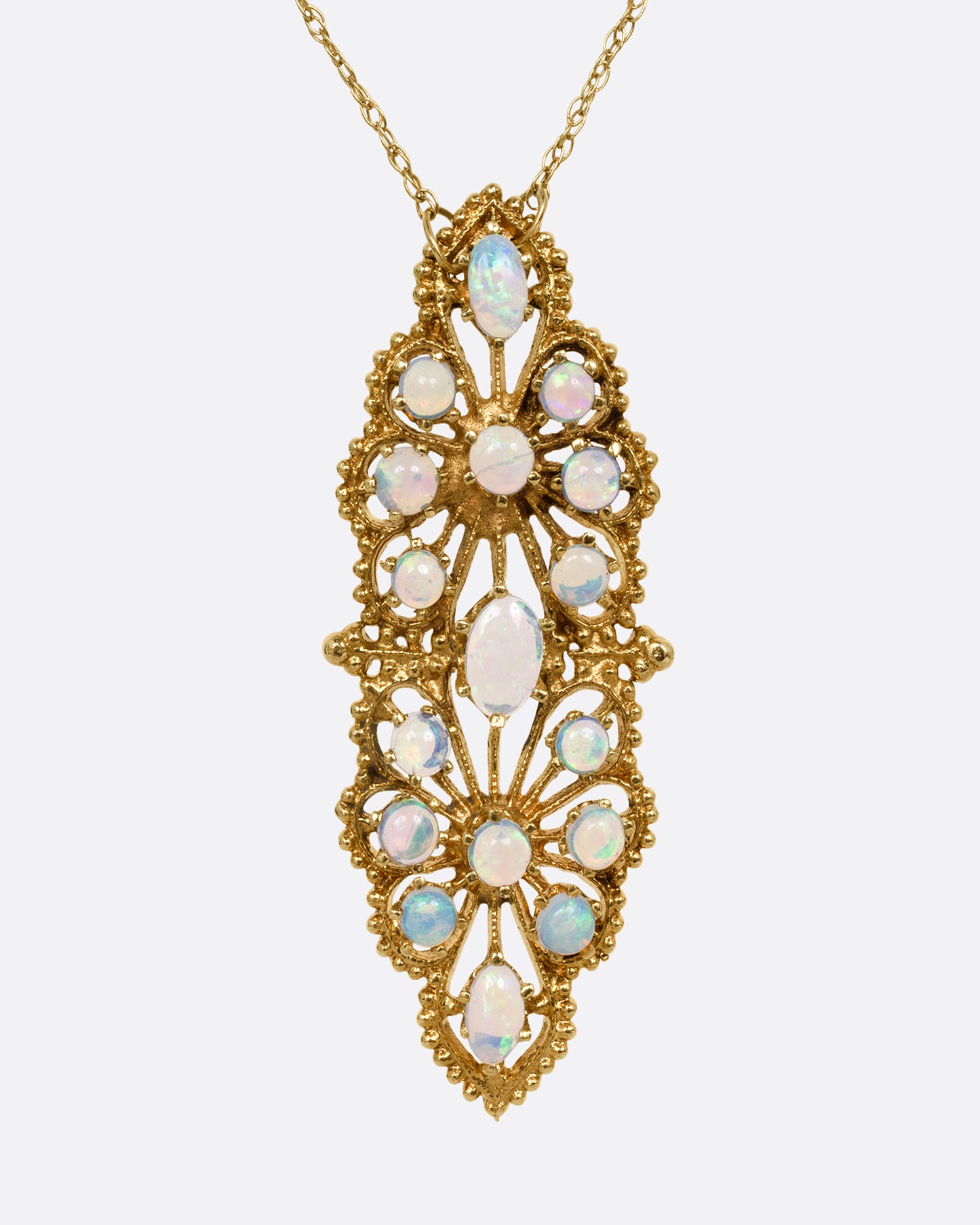 A yellow gold opal studded floral pendant, shown from the front on a cable chain.