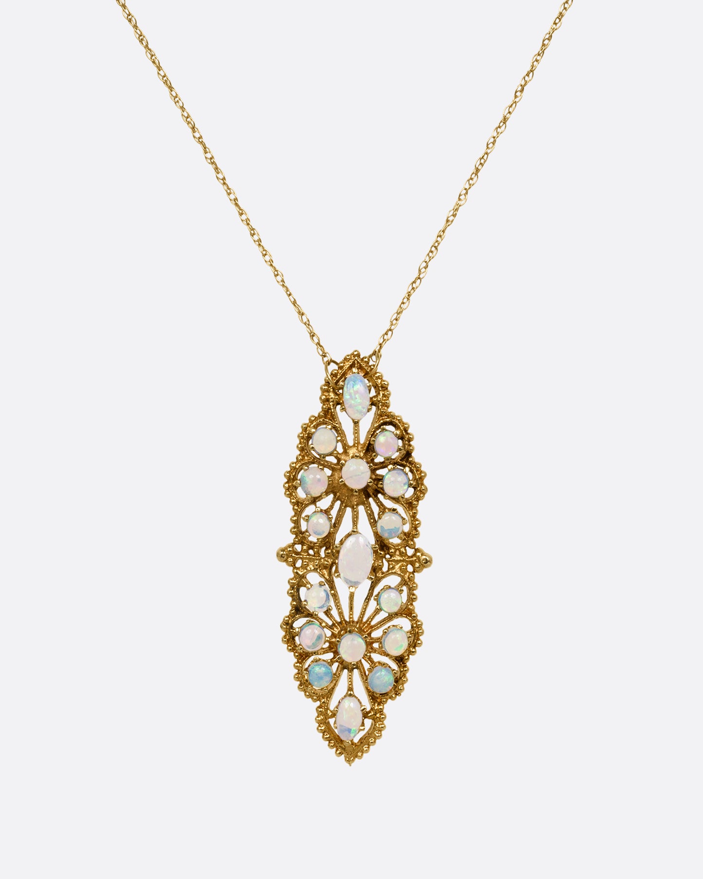 A yellow gold opal studded floral pendant, shown from the front on a cable chain.