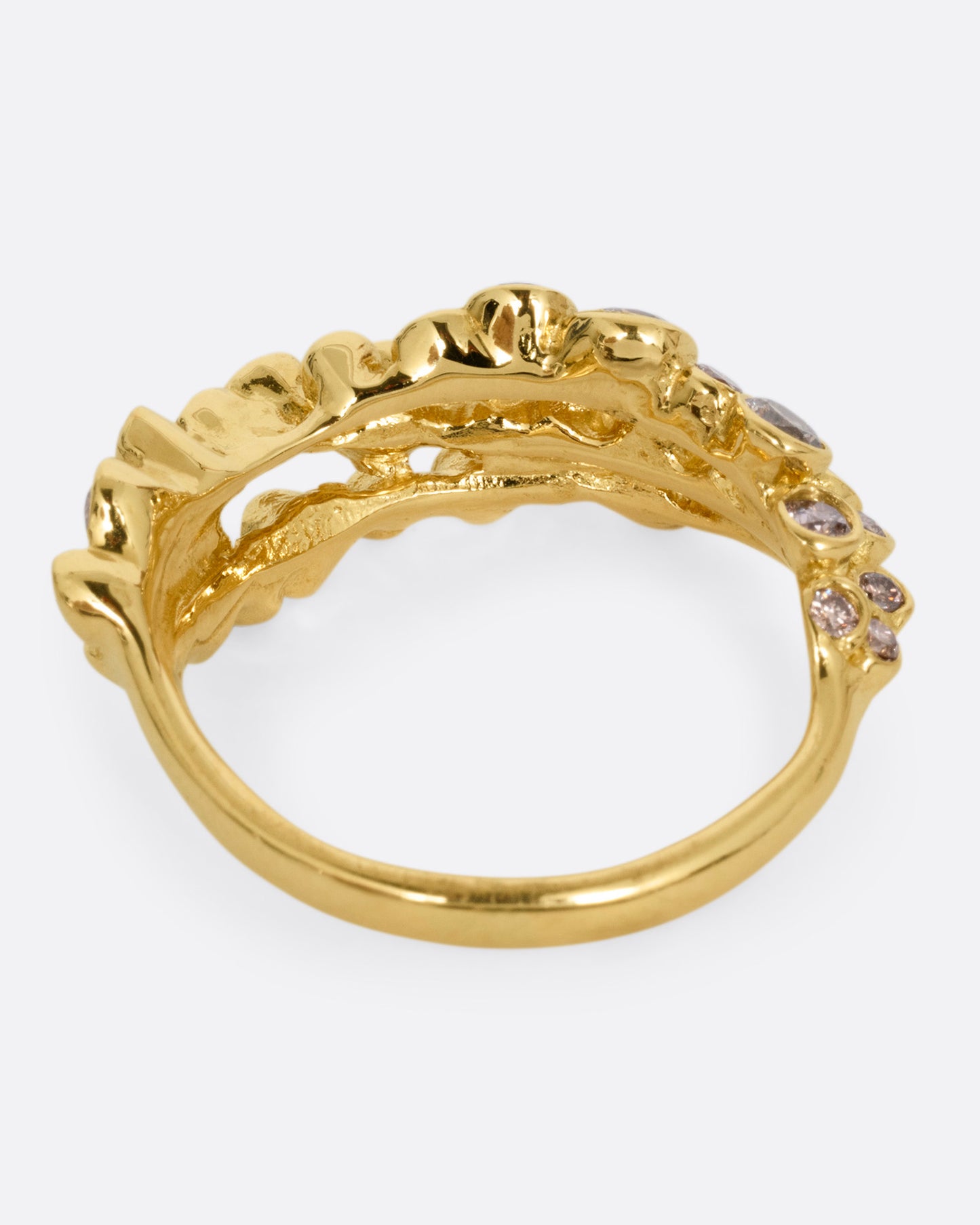 A yellow gold ring with layers of cognac diamonds, shown from the back.