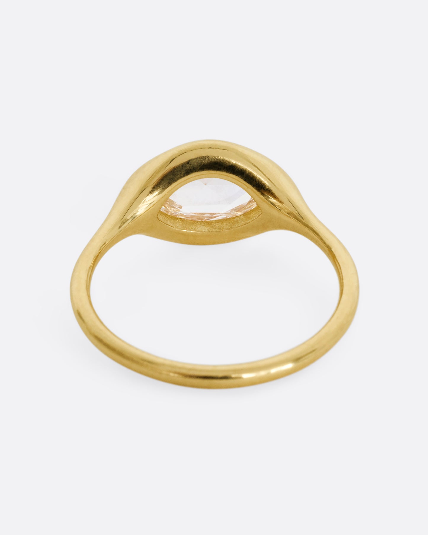 A yellow gold ring with a horizontal rose cut marquise diamond. Shown from the back.