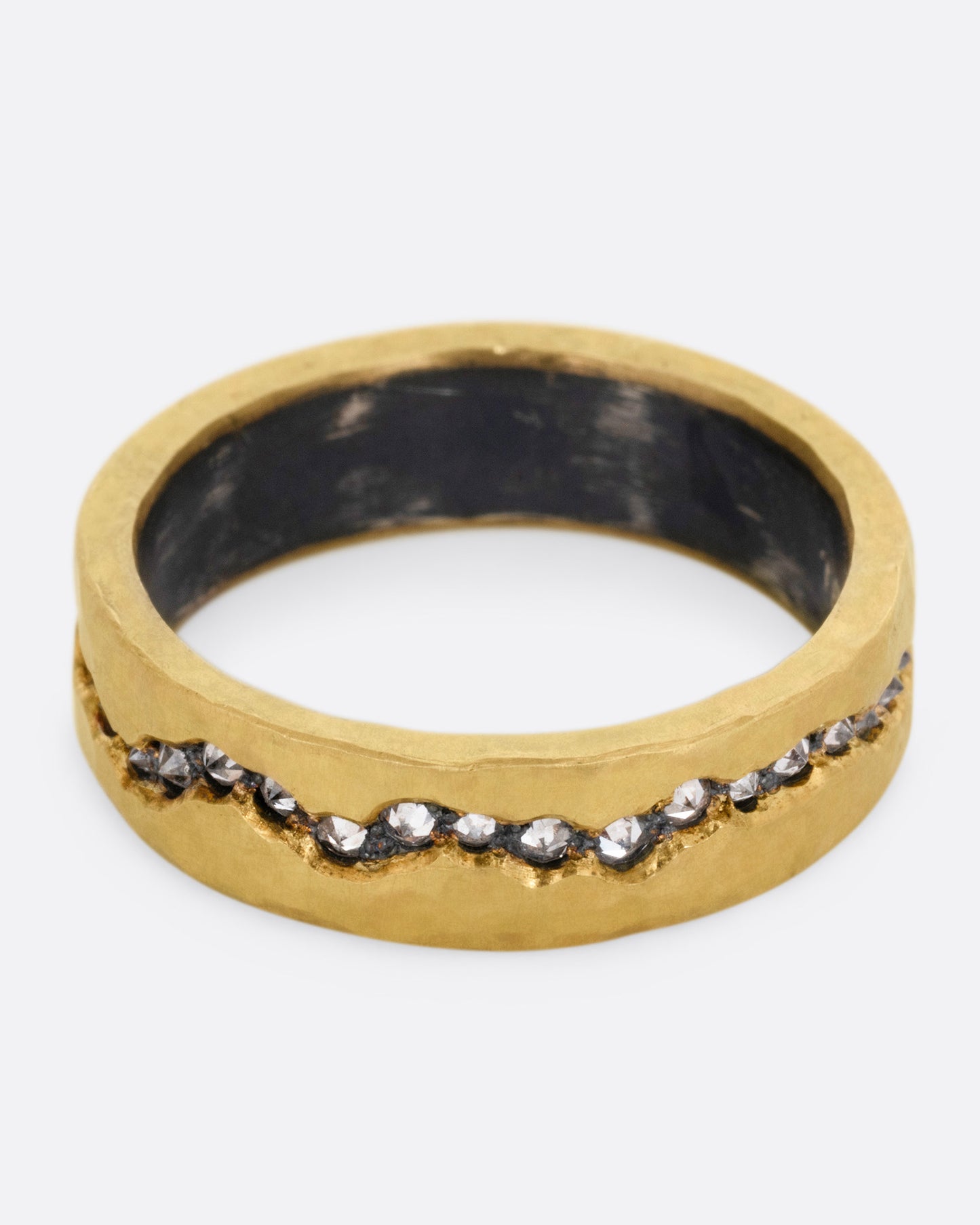 An oxidized silver ring with a yellow gold hammered finish and a fissure filled with inverted diamonds, shown from the front.