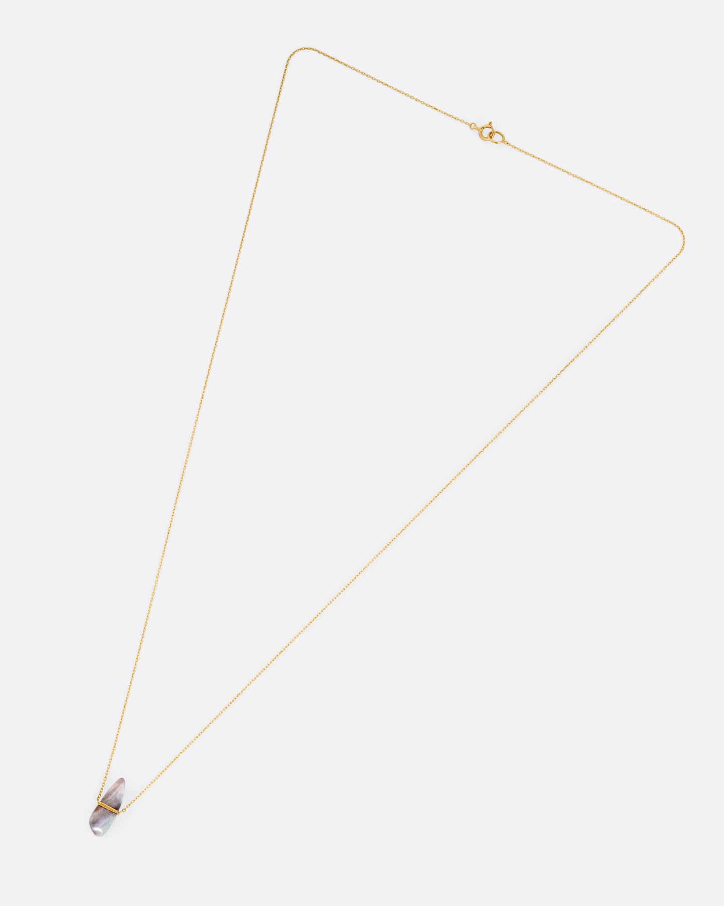 A yellow gold necklace with a freeform opal pendant, shown from the front.