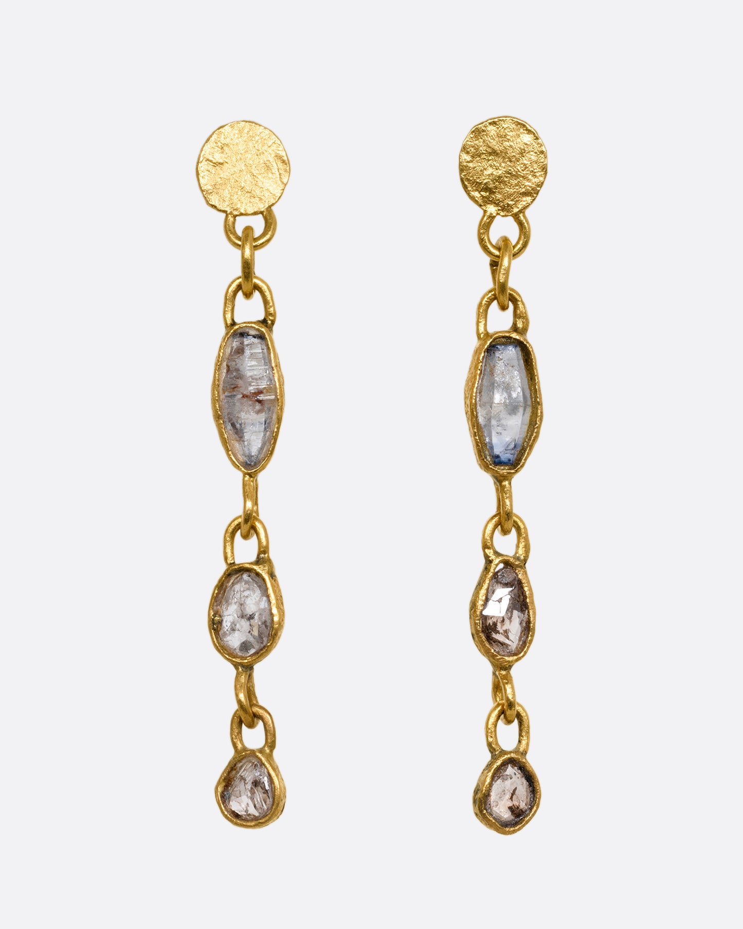 Yellow gold wrapped sapphire and diamond earrings falling from hammered gold discs. Shown from the front.