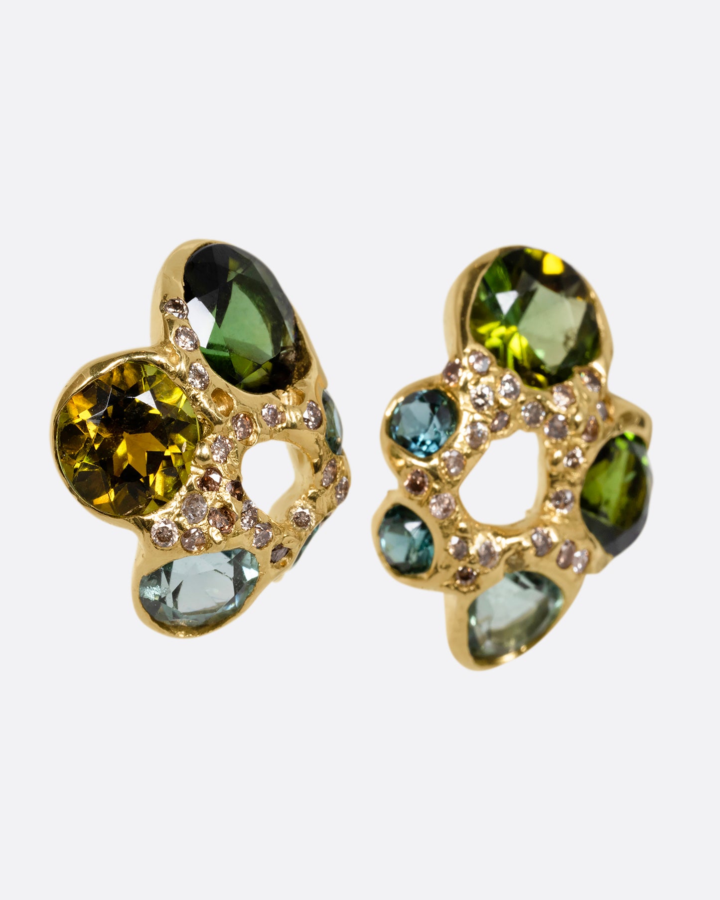 Yellow gold stud earrings with open centers and free- form tourmalines in varying shades of green. Tiny white diamonds are peppered throughout. Shown at an angle from the front.