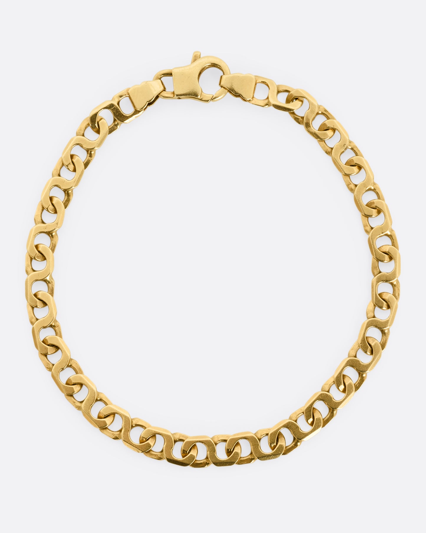 A yellow gold bracelet with infinity links Shown from above.
