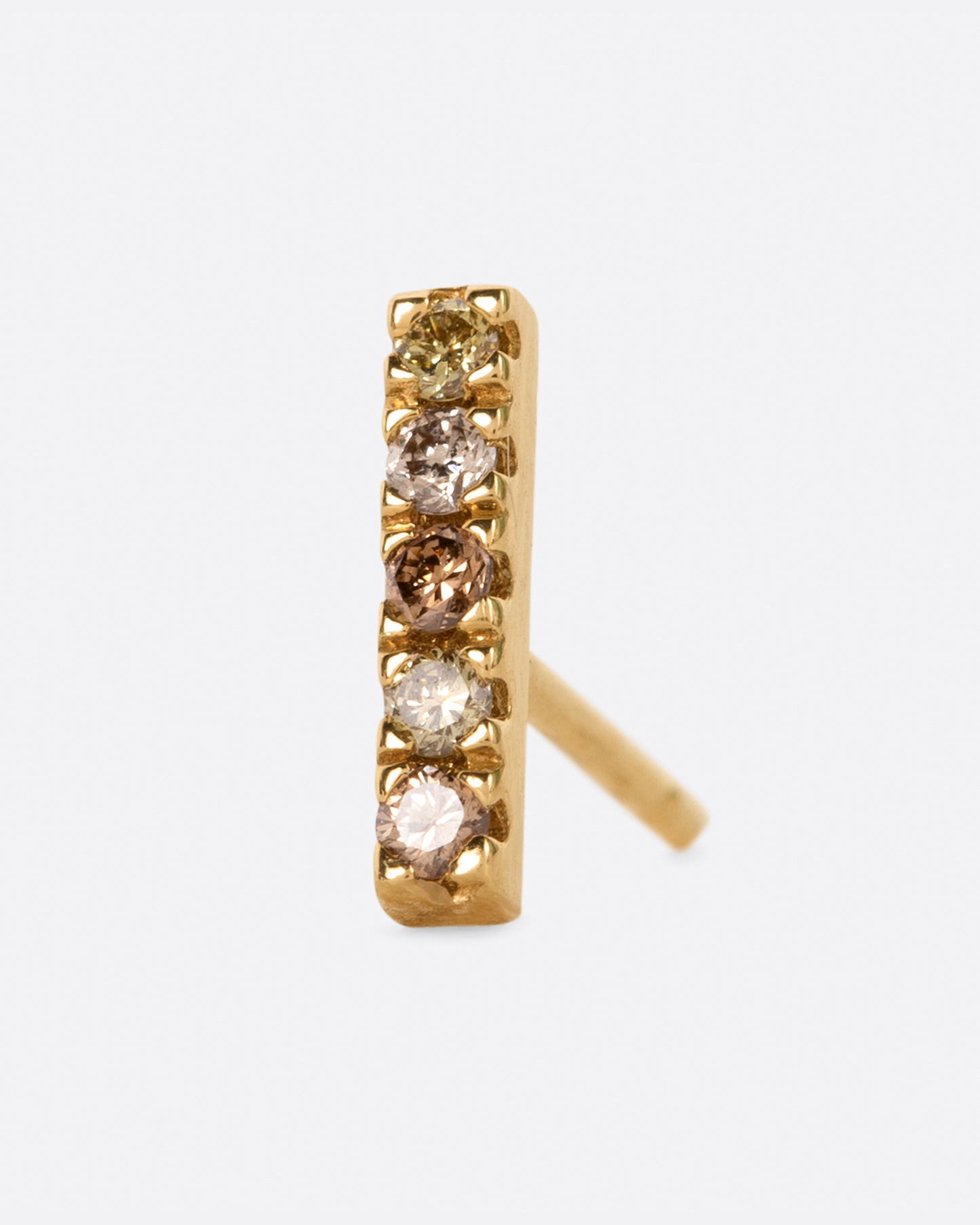 A yellow gold bar stud with a mix of five olive, dark and light champagne diamonds. Shown from the front.