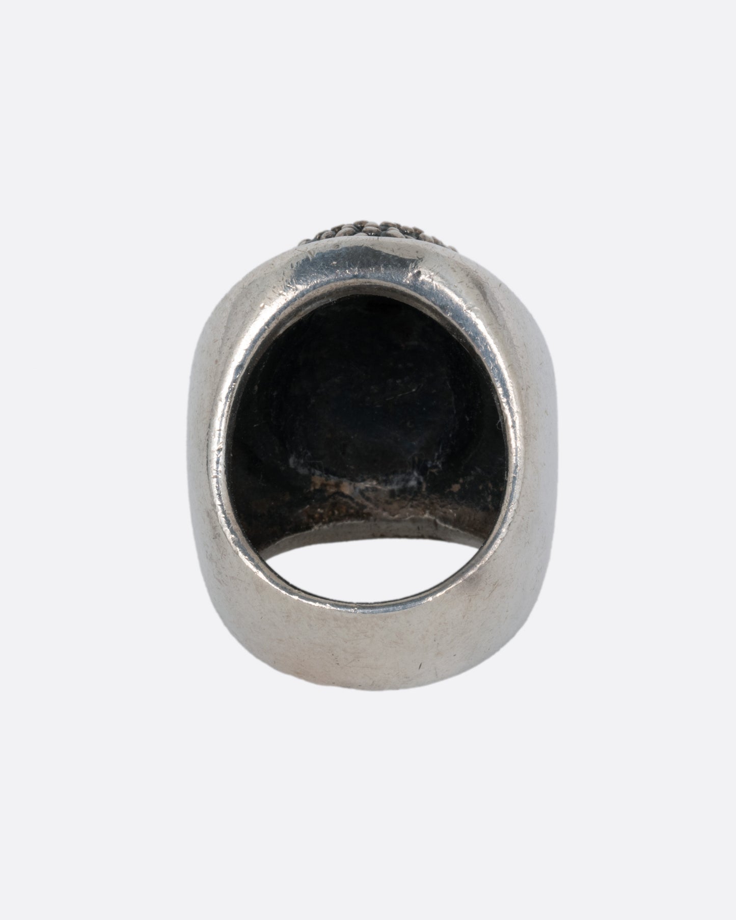 A silver ring with the Buddha's face. Shown from the back.