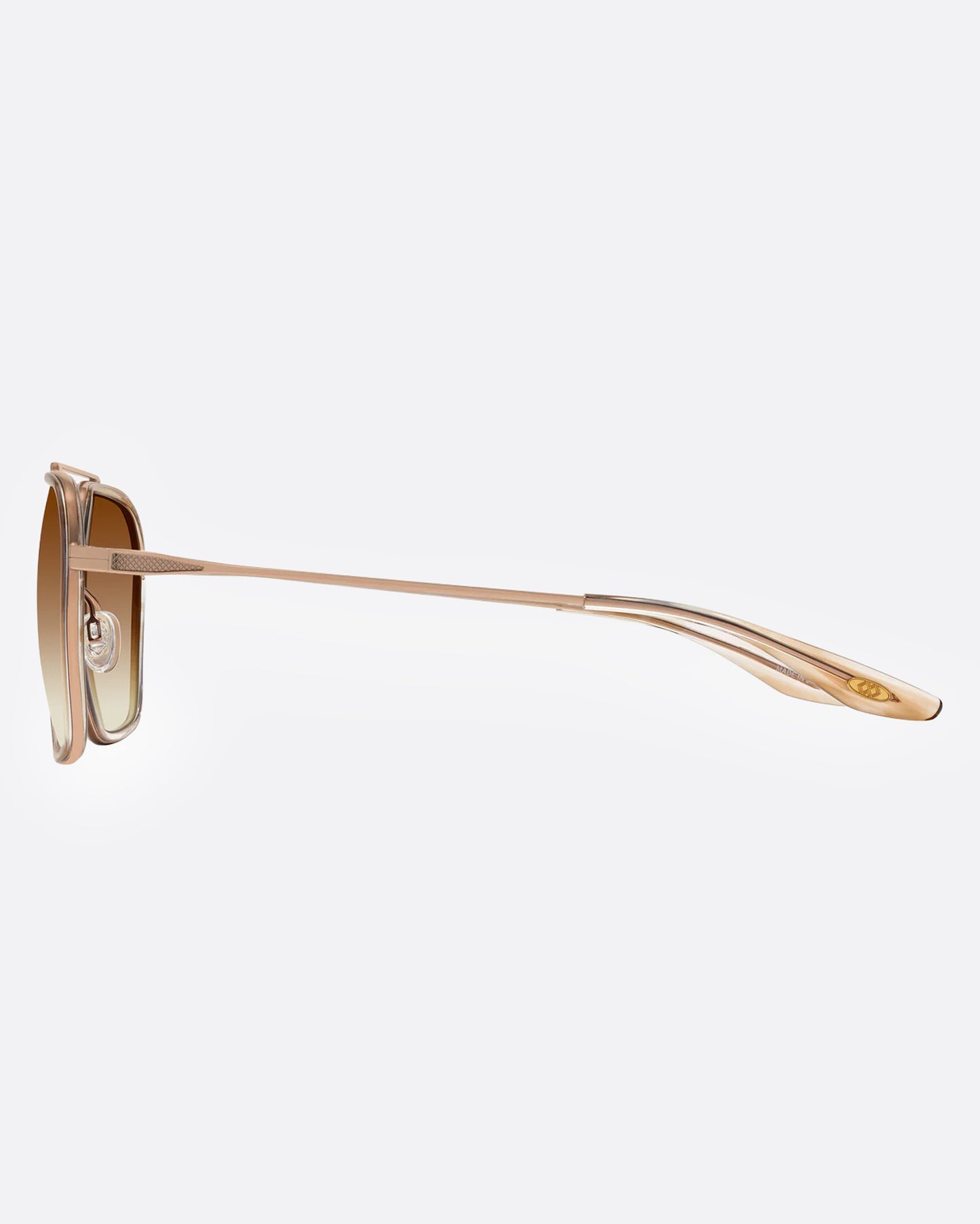 A pair of gold-framed aviator sunglasses with brown gradient lenses, shown from the side.