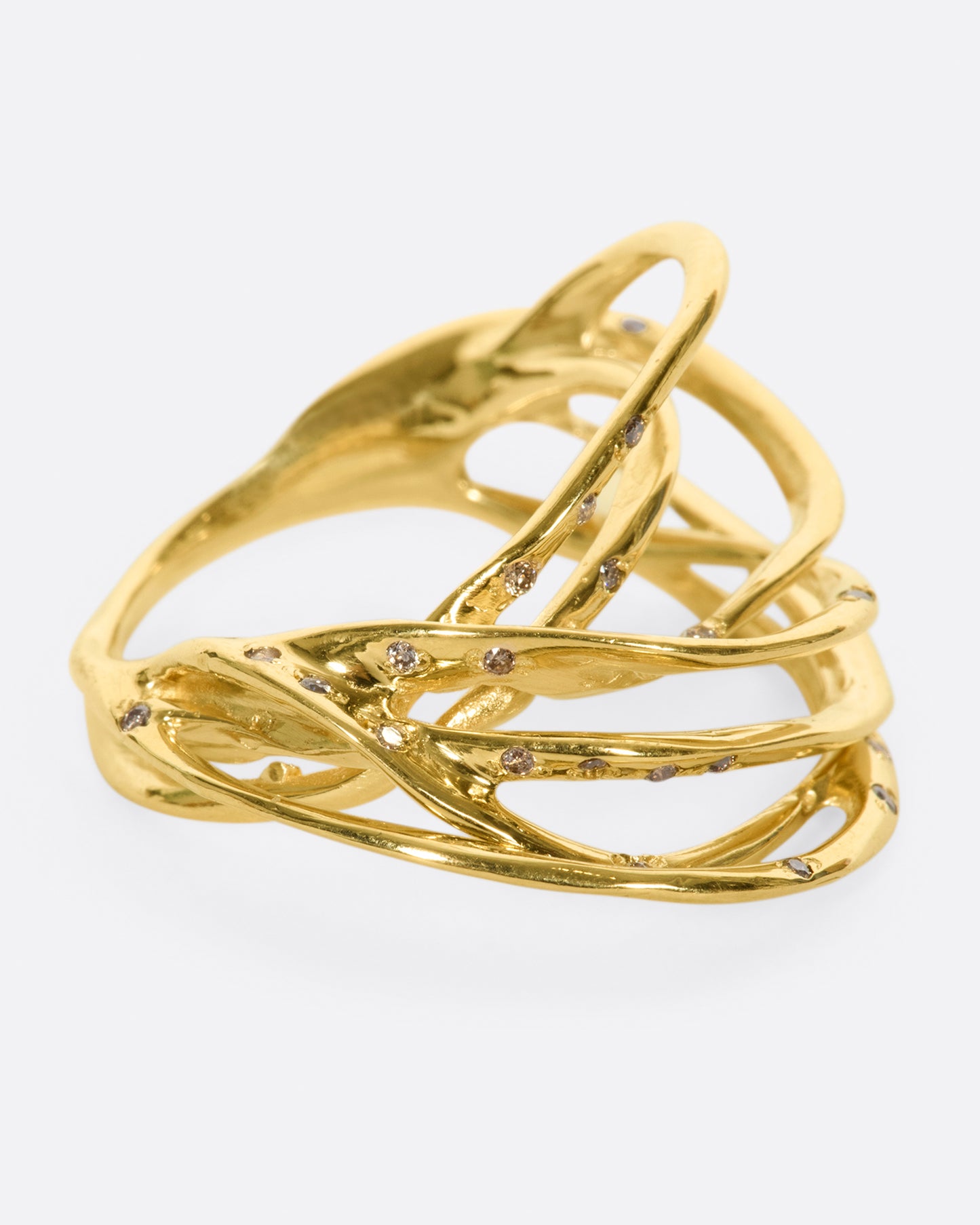 A yellow gold ring formed from multiple strands of gold, dotted with cognac diamonds. Shown from the side.