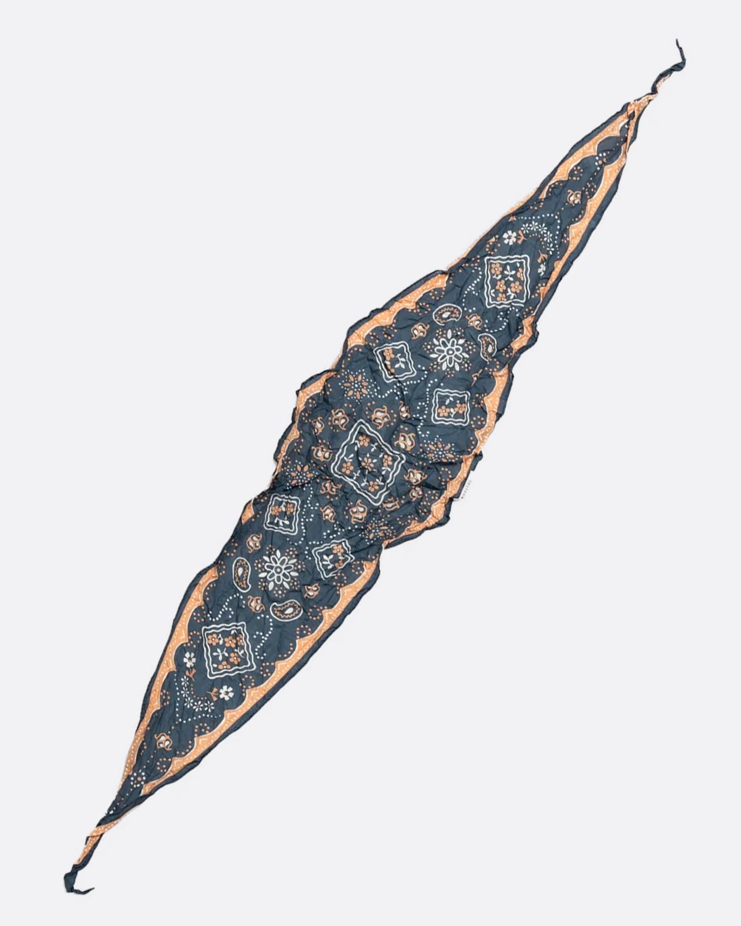 A navy colored diamond-shaped neckerchief with a paisley motif. Shown lying flat.