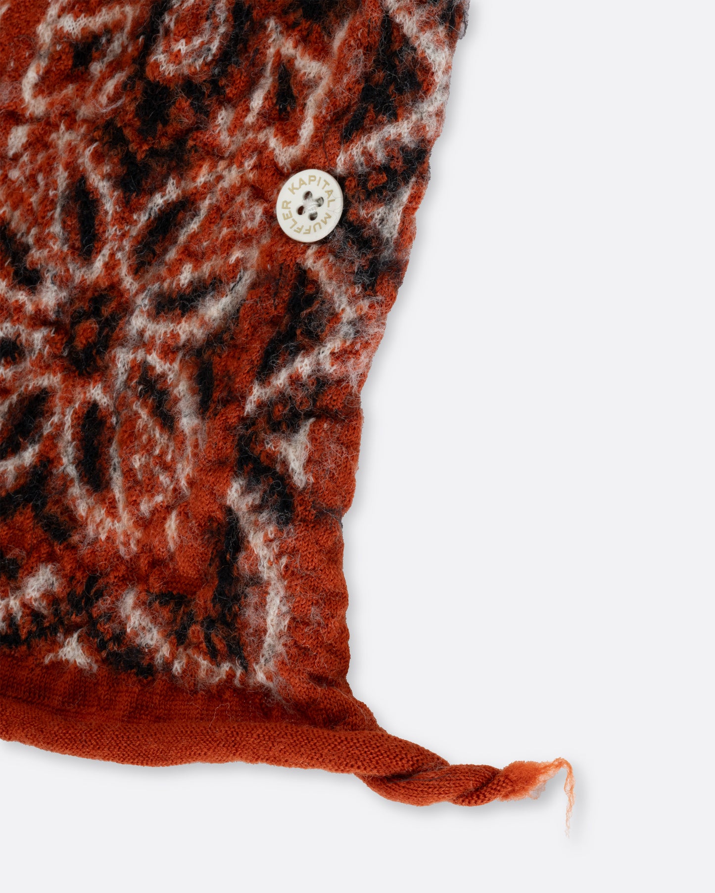 A close up of a red compressed wool scarf with a classic bandana pattern.