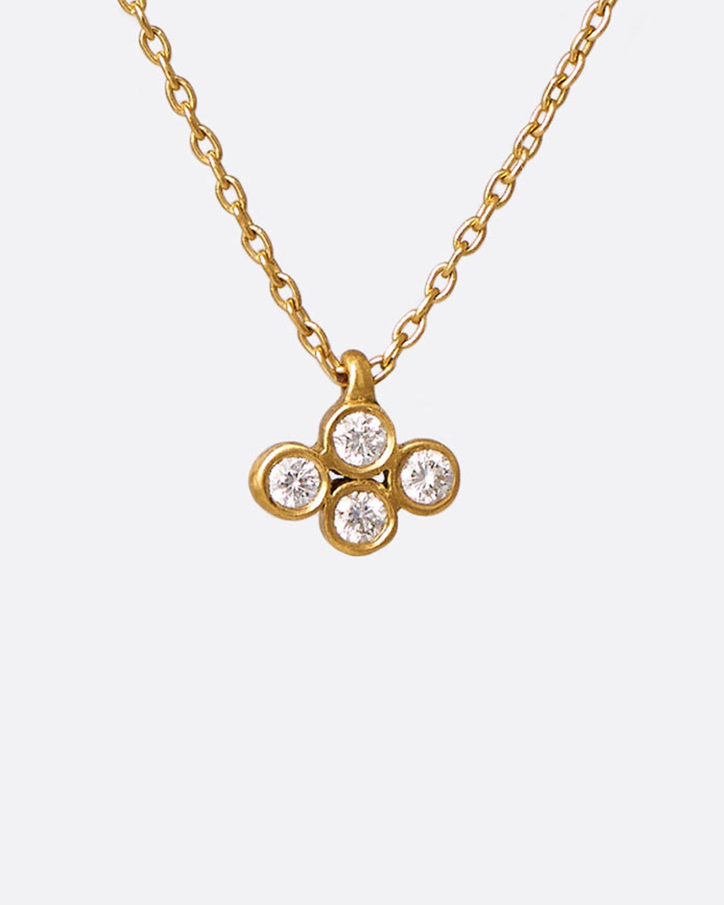 A yellow gold cable chain necklace with a pendant of four two point diamonds. Shown from the front.