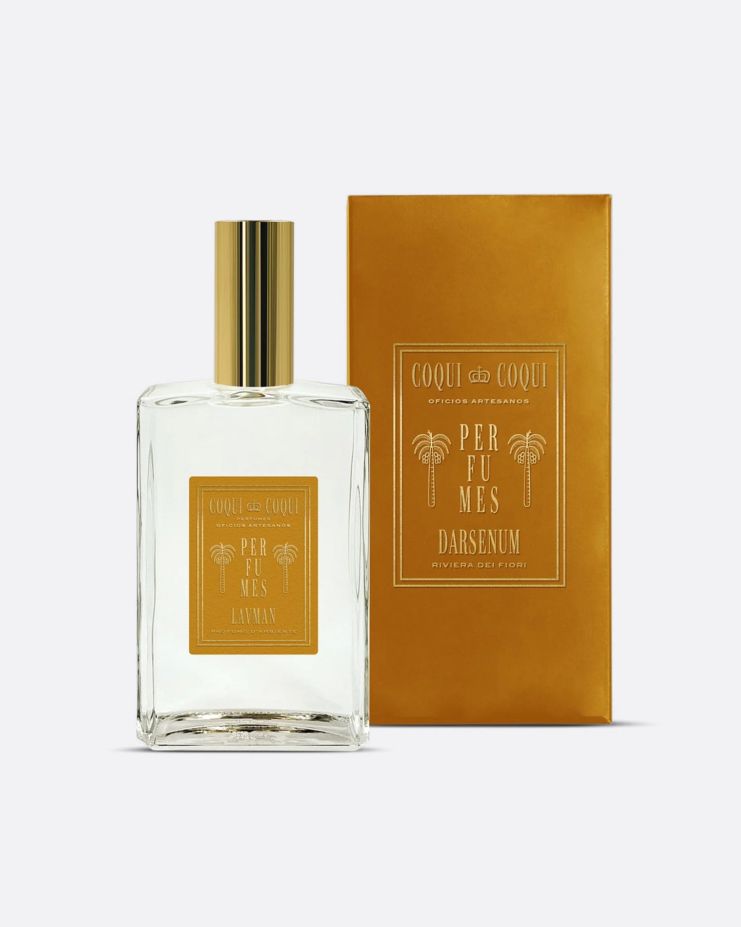A linen spray glass bottle with gold cap and gold label shown next to its gold box, from the front.