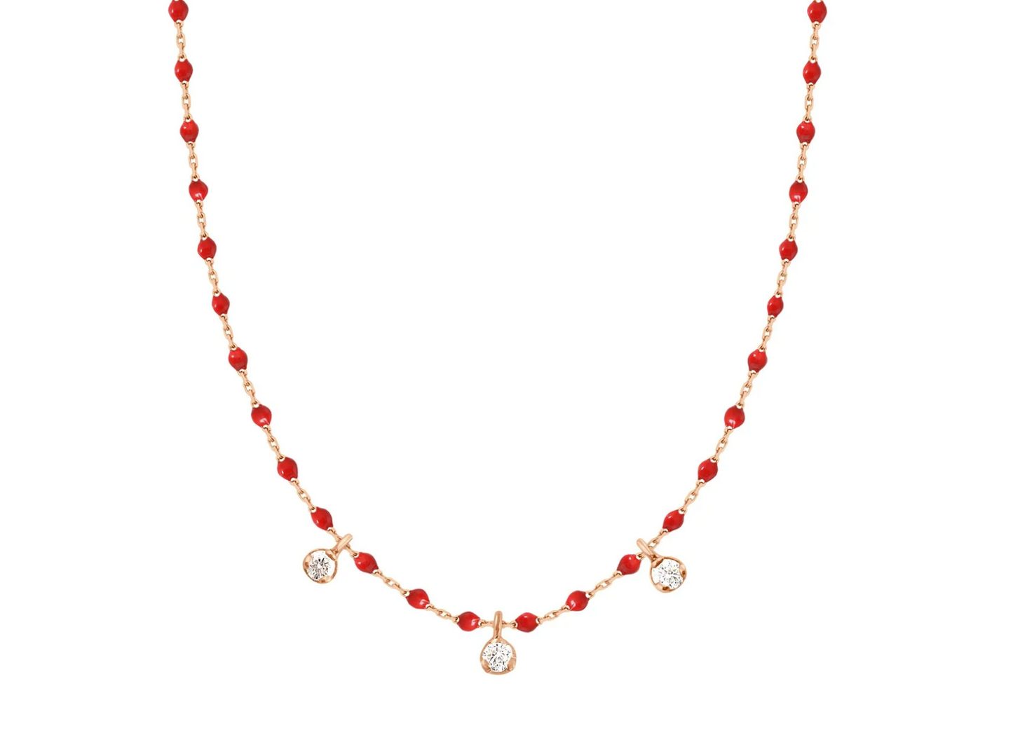 A rose gold cable chain necklace with droplets of red resin and three diamond charms. Shown from the front.