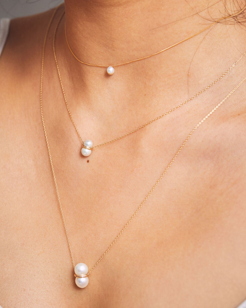 womans neck with three pearl necklaces of different sizes on. the large one is the one on this product page.