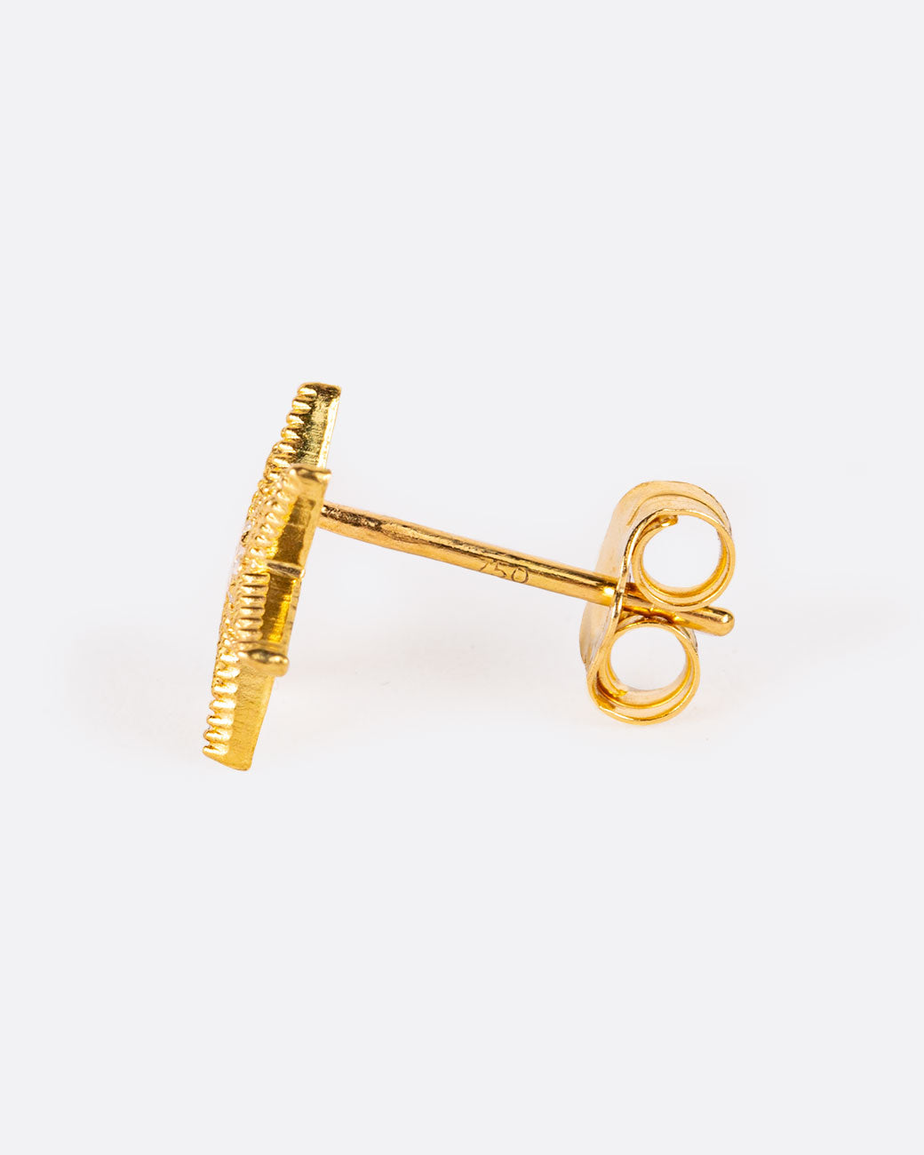 A six point star with millgrain texture and a bright white diamond center. Shown from the side.