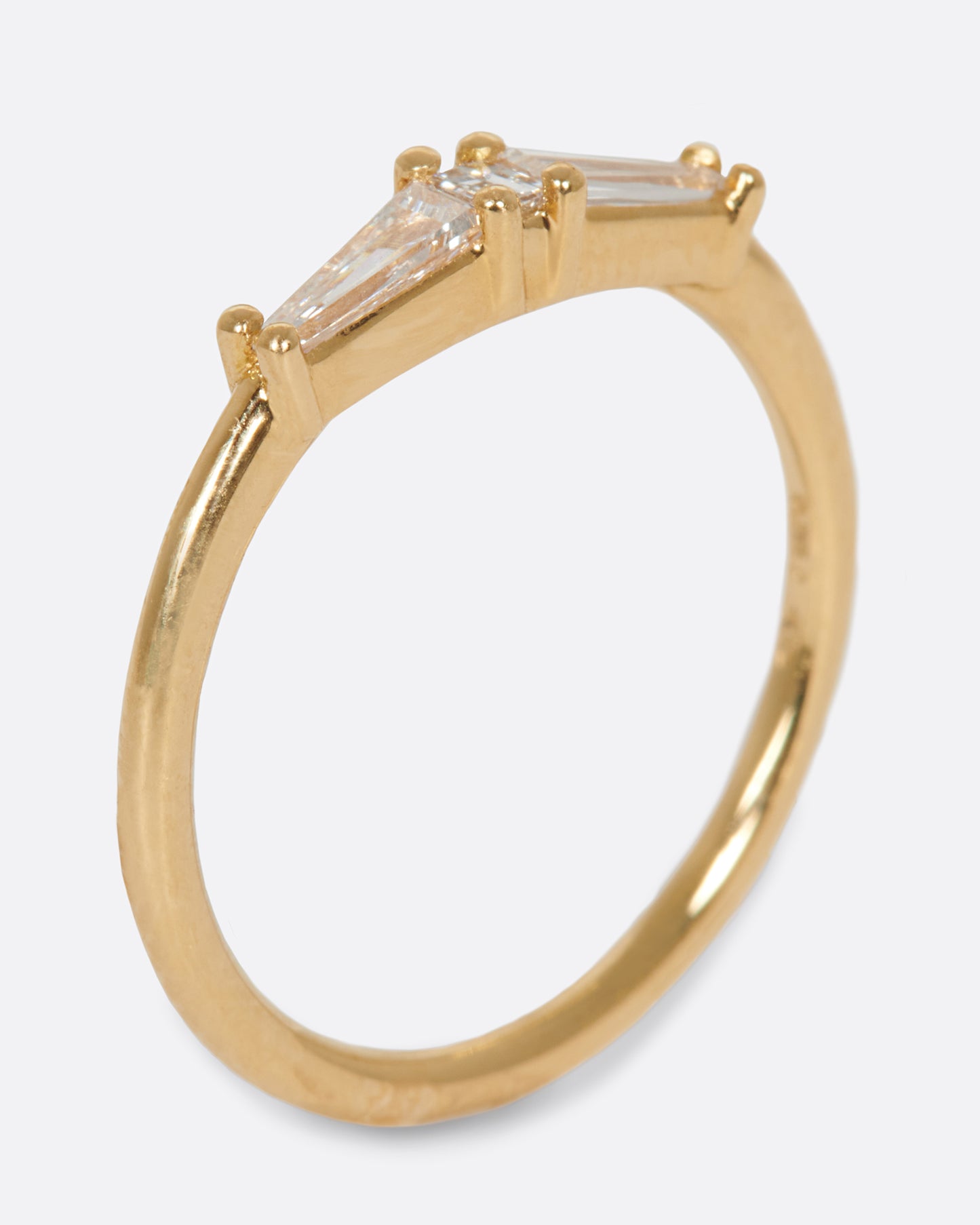 A ring featuring two tapered baguette diamonds and one carre cut diamond; perfect for stacking.