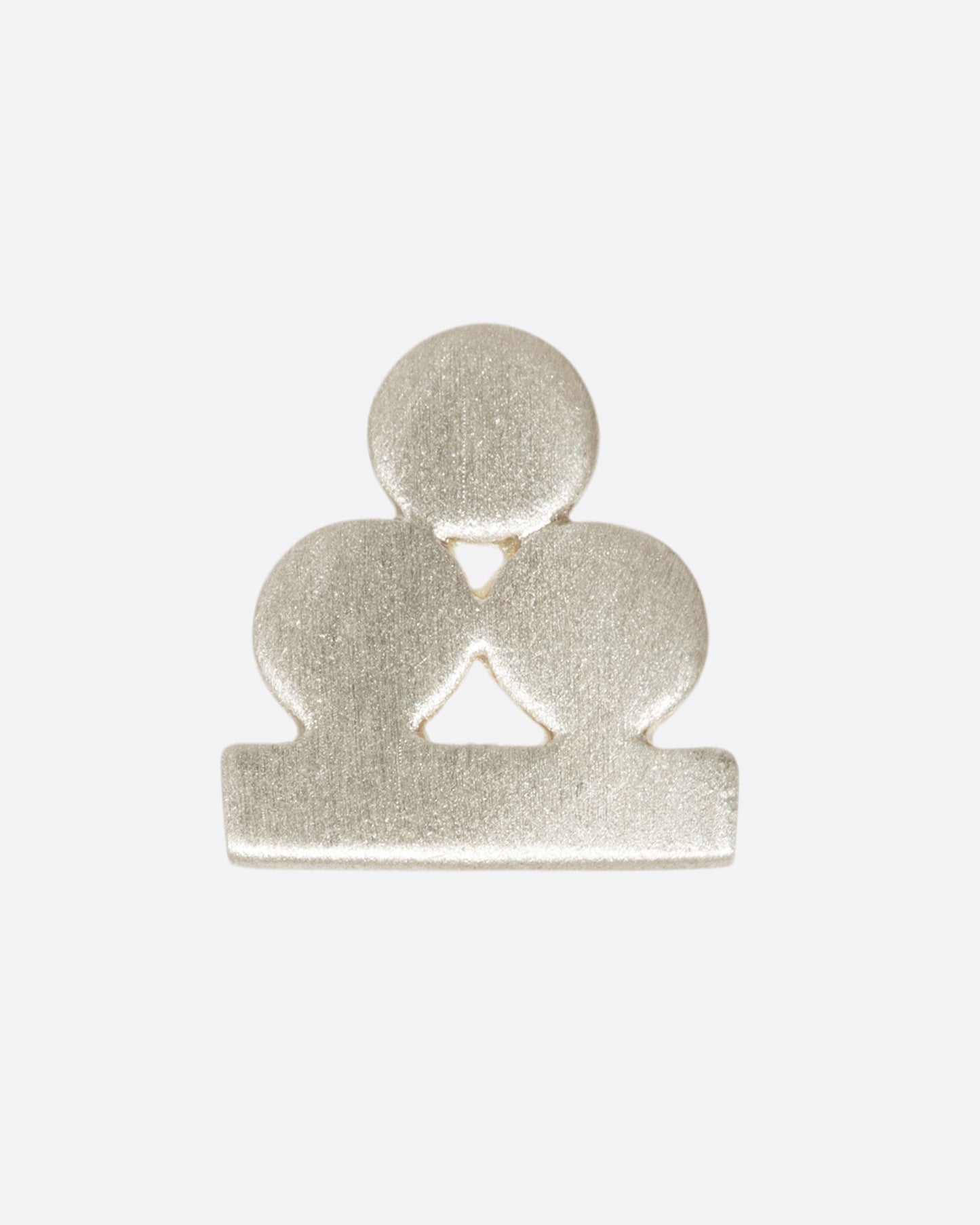 A silver stud earring with three matte circles sitting on a bar. Shown from the front.