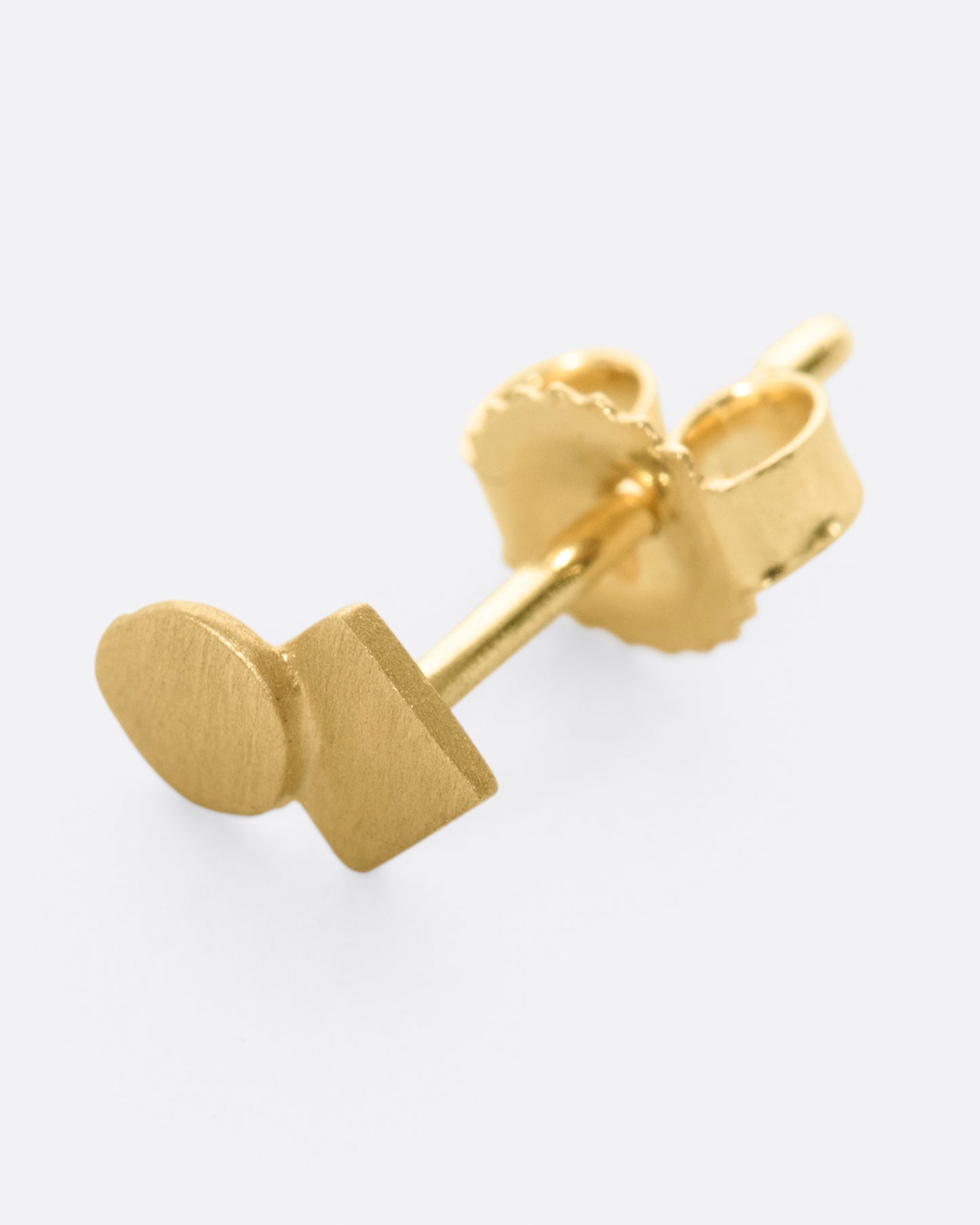 A yellow gold stud earring with overlapping circle and matte finish. Shown lying flat from the front.