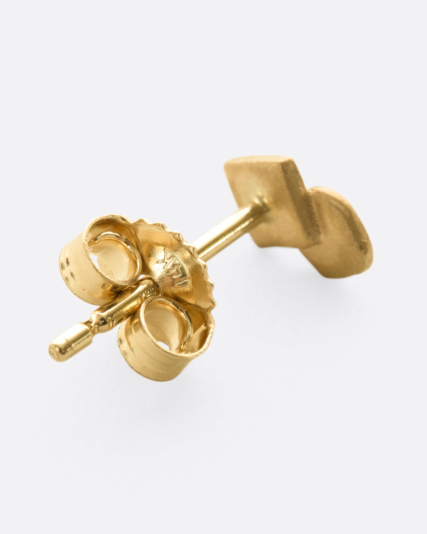 A yellow gold stud earring with overlapping circle and matte finish. Shown lying flat from the back.