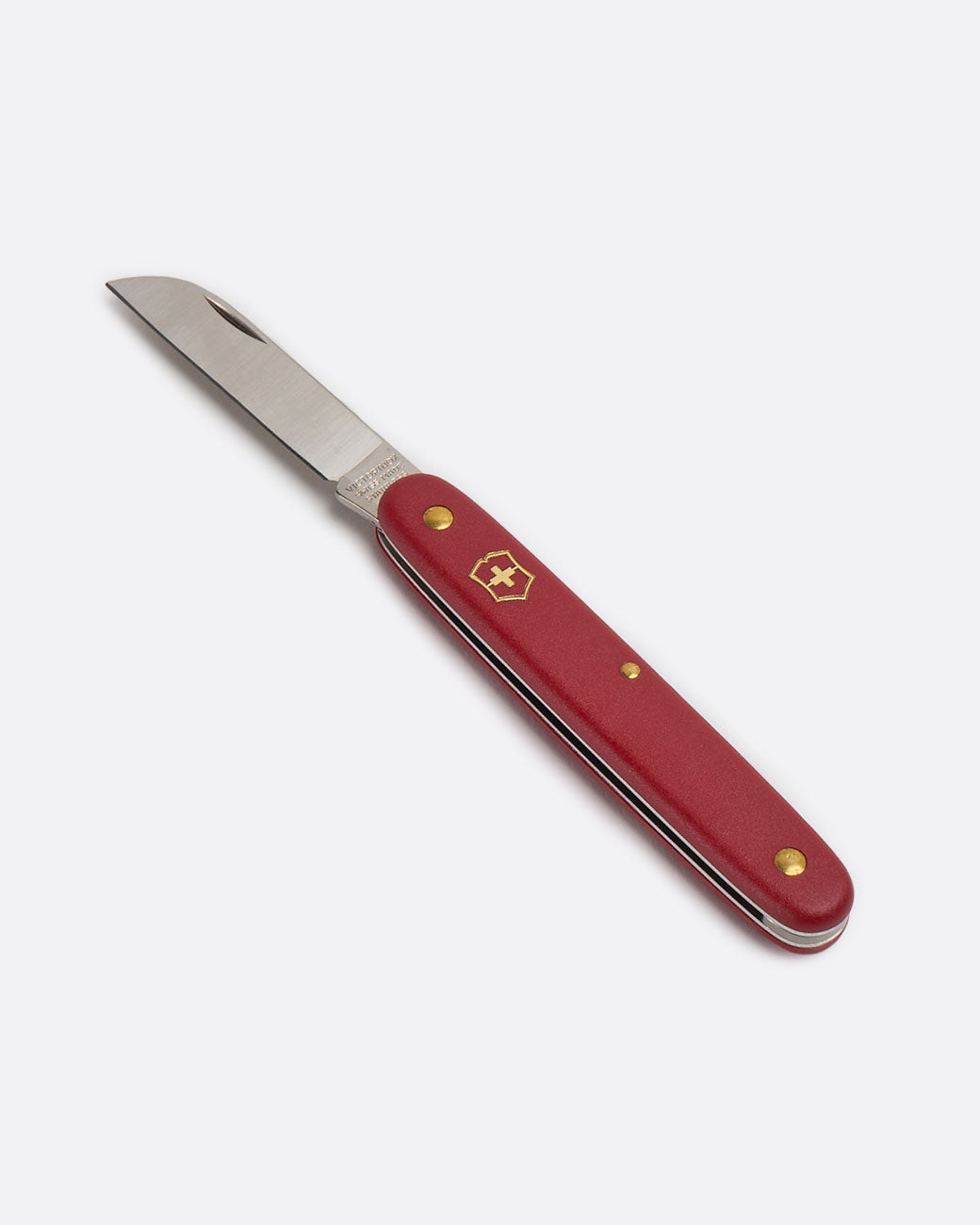 A Victorinox floral knife with red handle, shown open lying flat from the side.