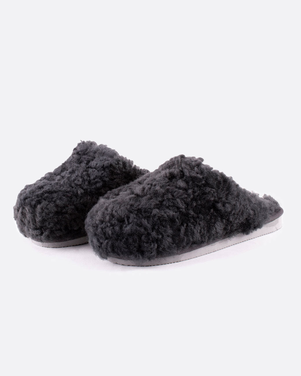 A pair of Jenny sheepskin slippers in charcoal gray, shown from the side.