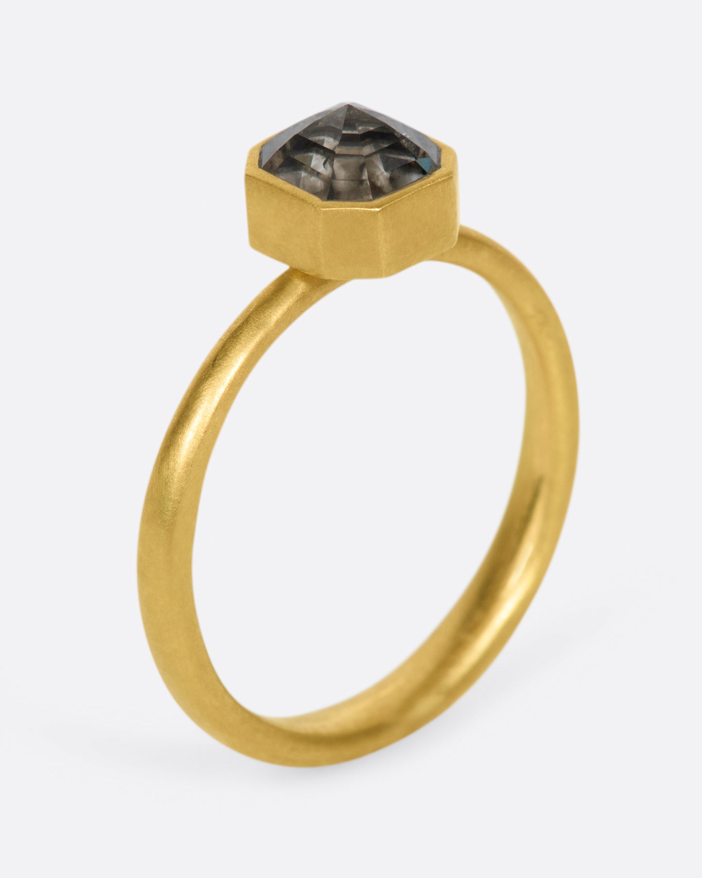 A yellow gold ring with a smokey octagonal diamond. Shown standing up from the side.