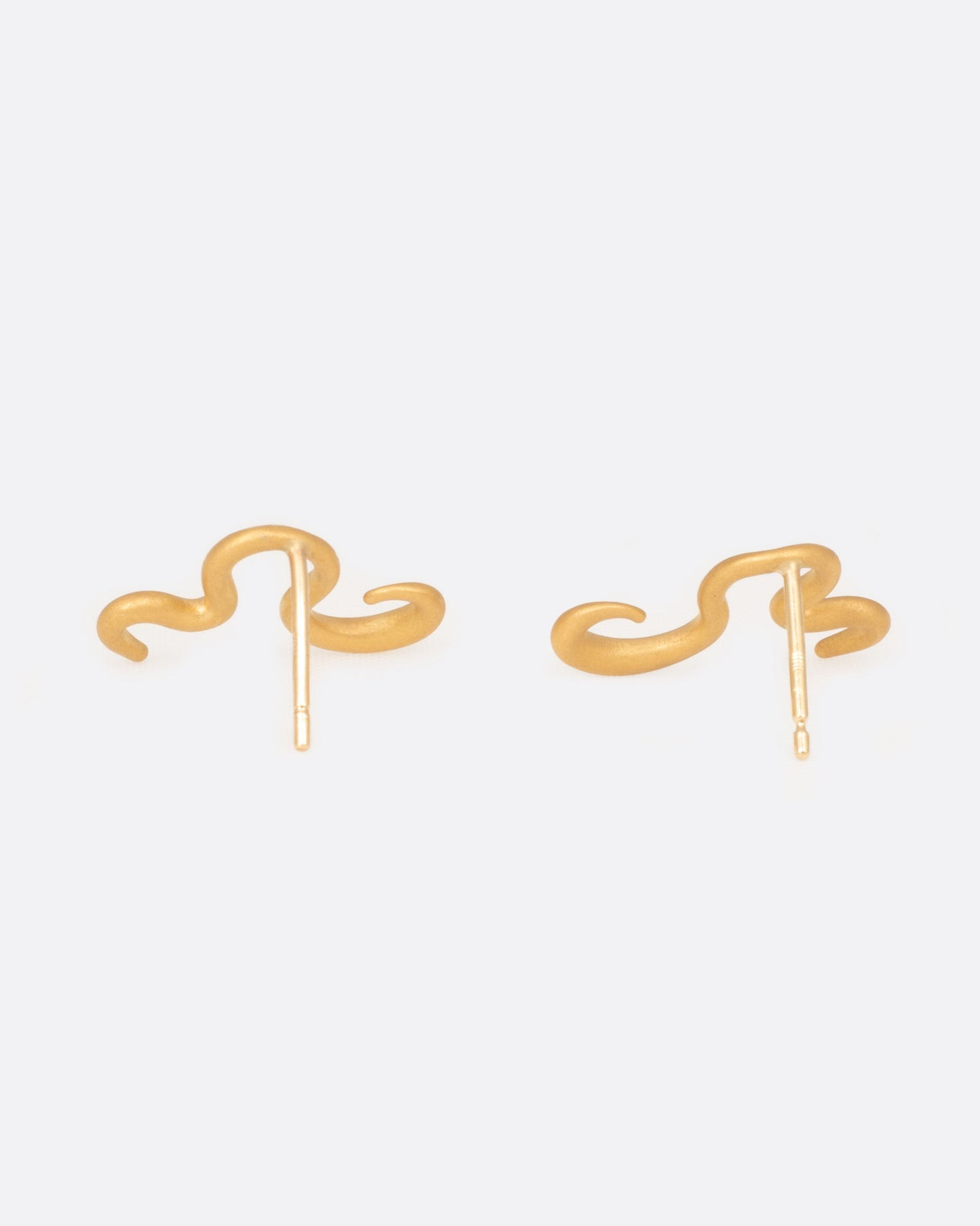 A pair of curved 22k yellow gold snake stud earring. Shown from the back.