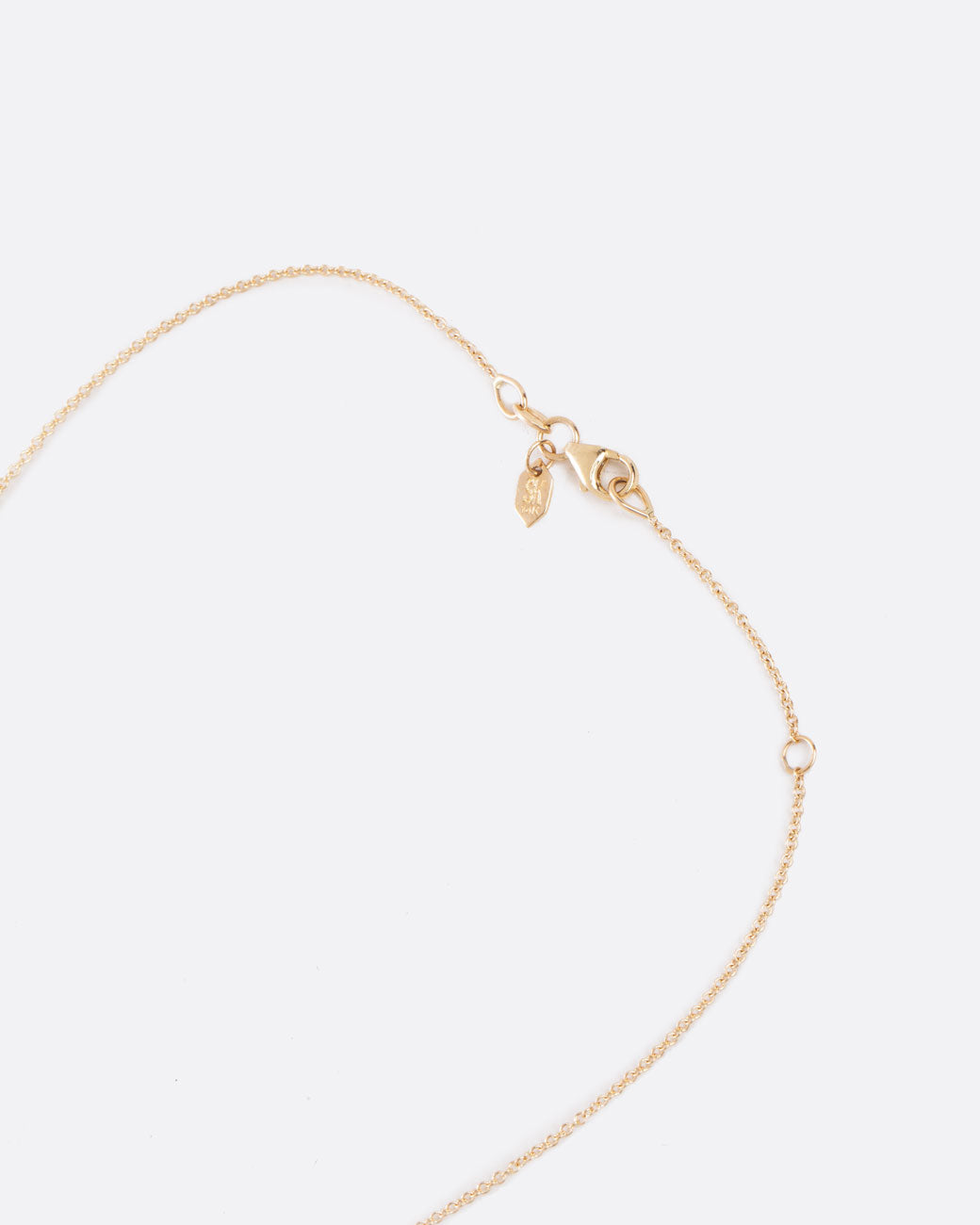 Close up birds eye view of yellow gold chain with a closed clasp.