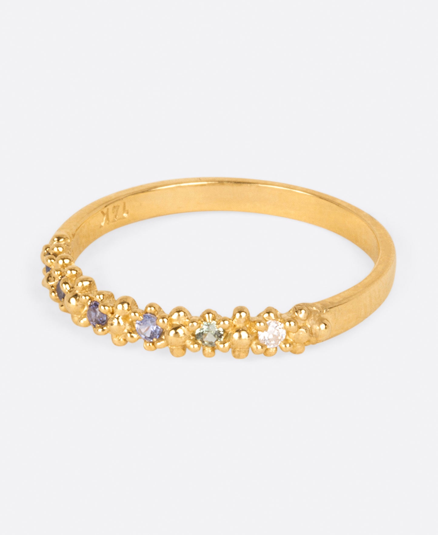 A textured yellow gold band with an ombré queue of six sapphires shown from the side.