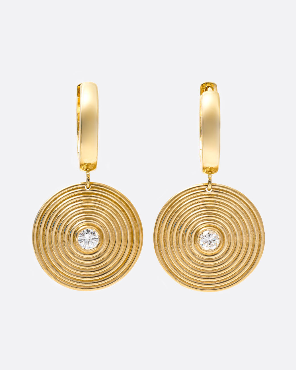A pair of yellow gold hoop earrings with circular ribbed disc drops with white diamond centers, shown from the front.