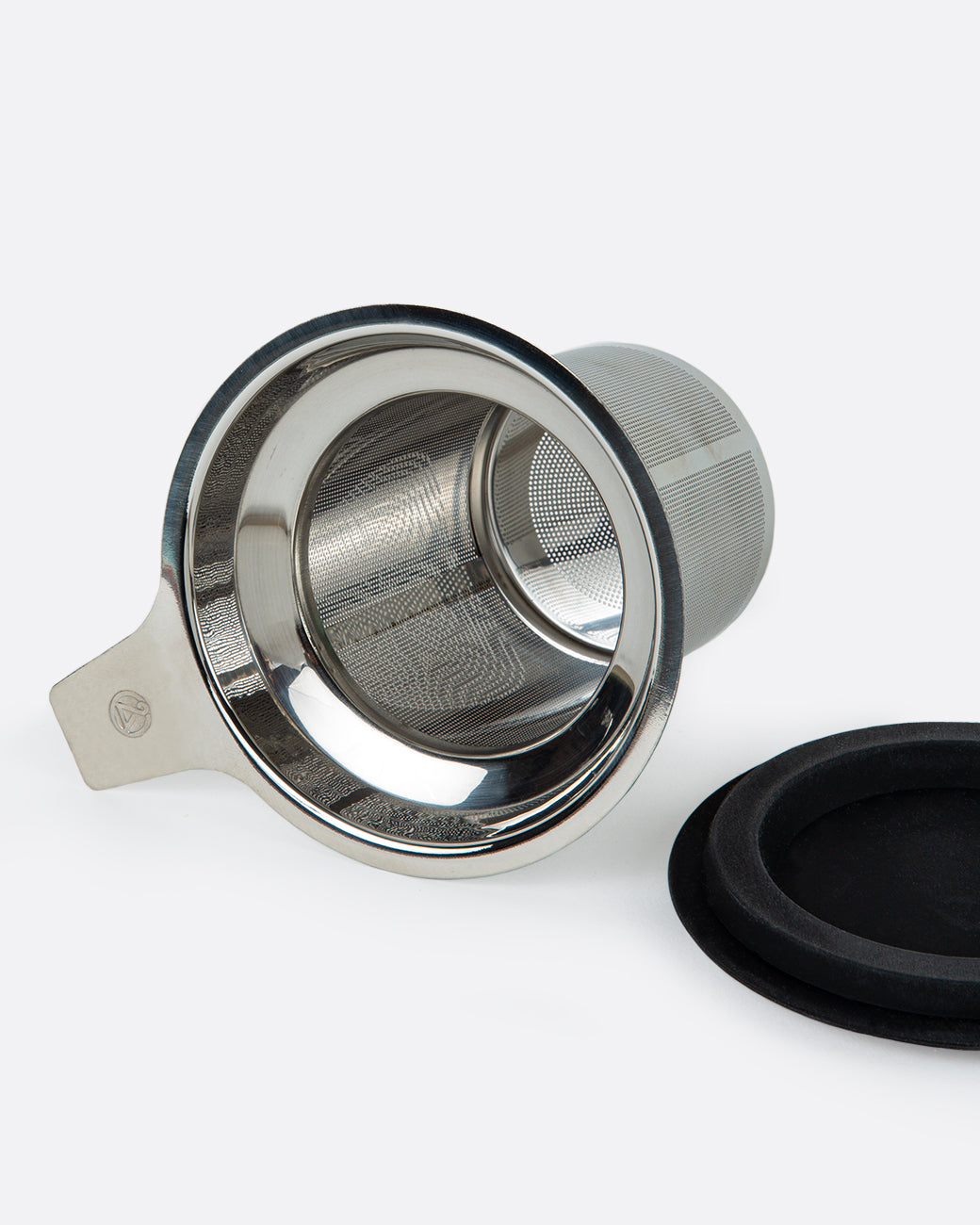 A tea diffuser lying on its side with a lid next to it. Shown from the top.