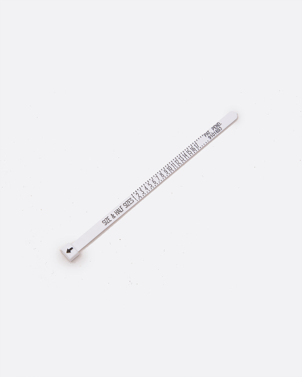 A white ring sizer with black numbering shown lying flat from an angle.