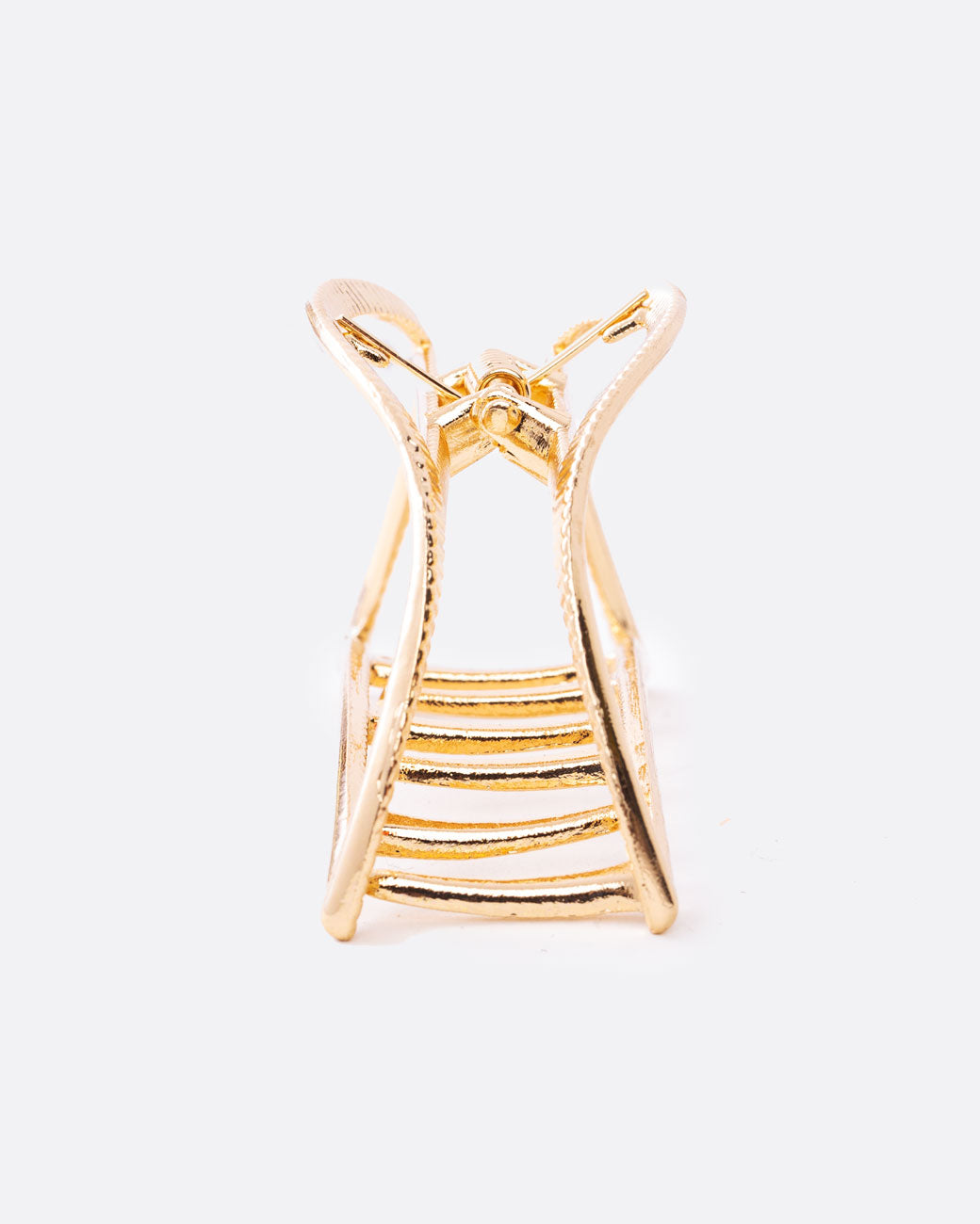 A gold hair clip with a spring loaded top and teeth at the base. Shown from the front.