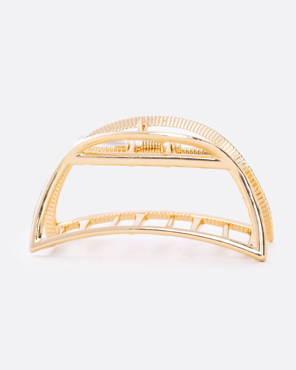 A gold hair clip with a spring loaded top and teeth at the base. Shown from the side.
