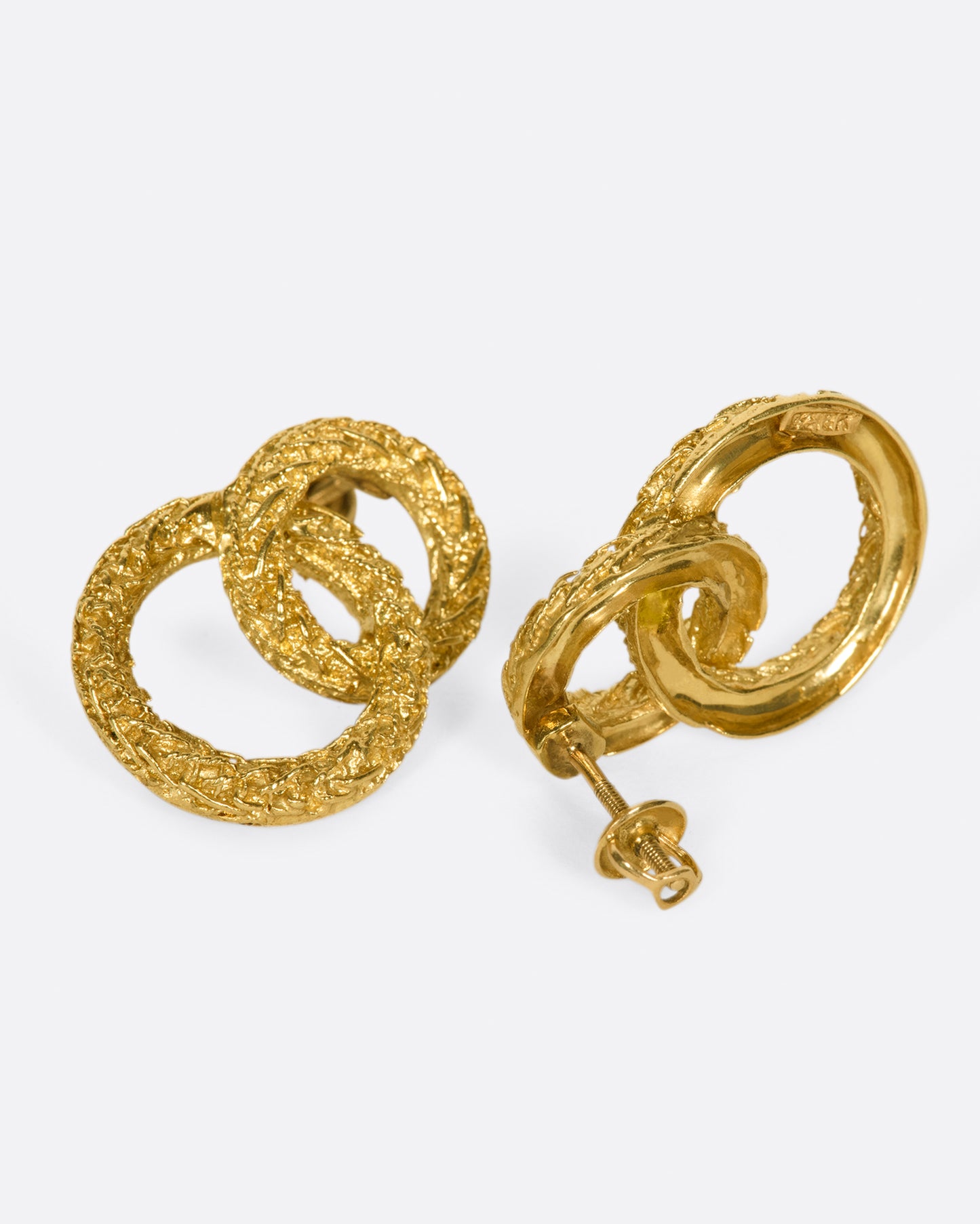A pair of textured double-circle stud earrings. One earring is shown from the front, the other from the back.