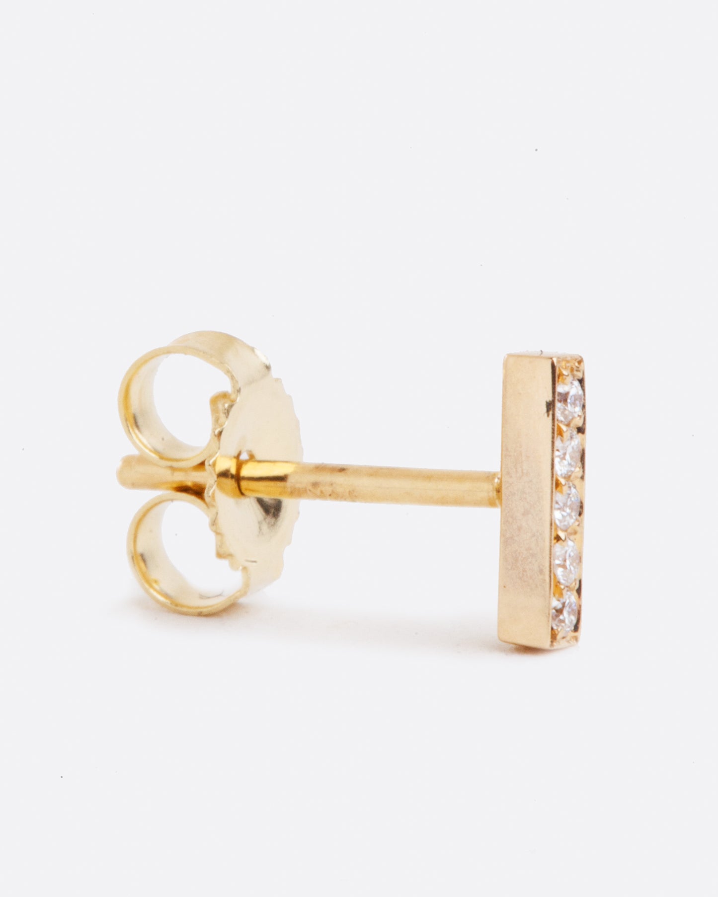 14k yellow gold bar stud earring with five white diamonds by Selin Kent, shown standing up from the side.